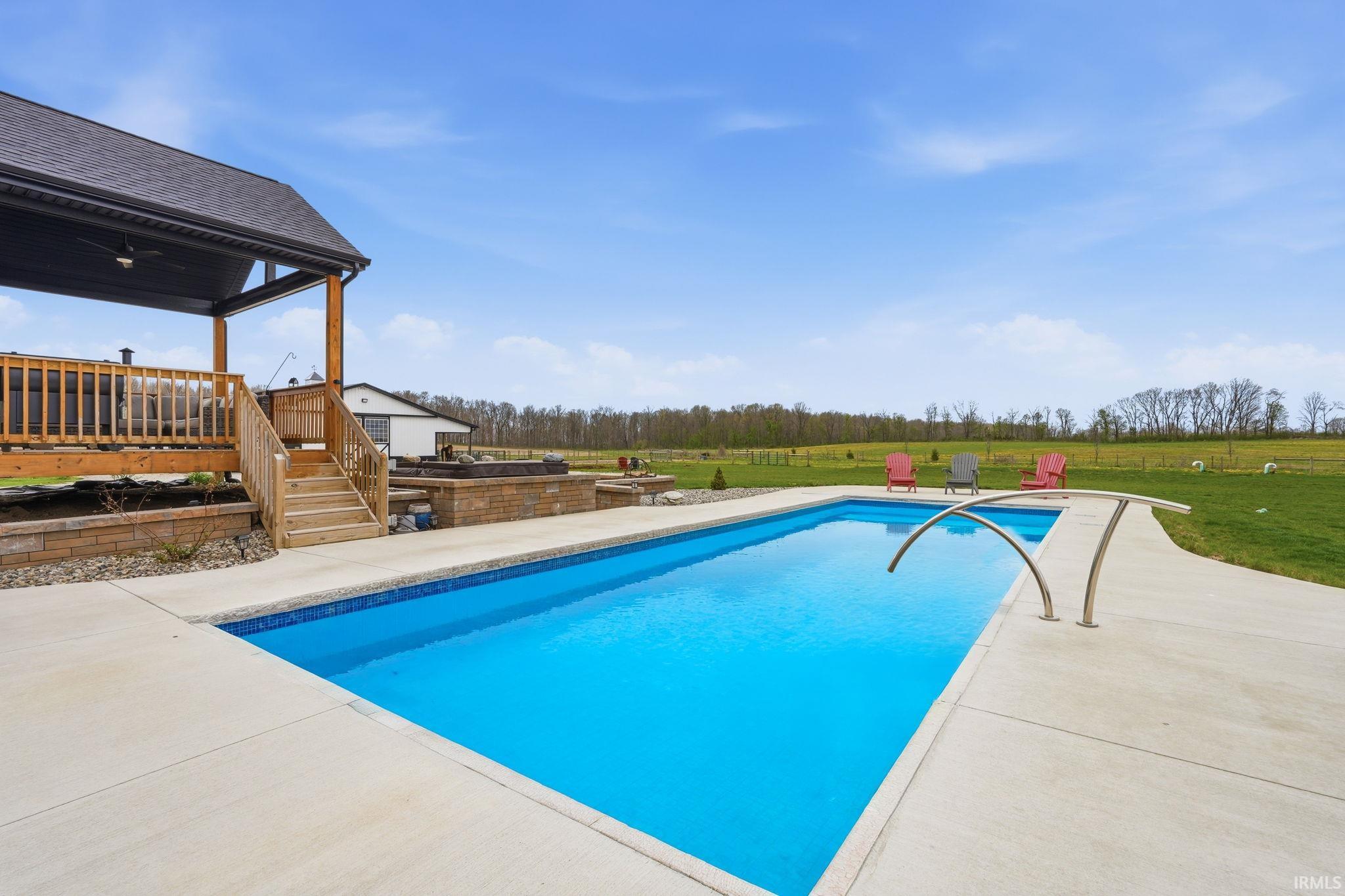 Swimming pool with a patio and a lawn