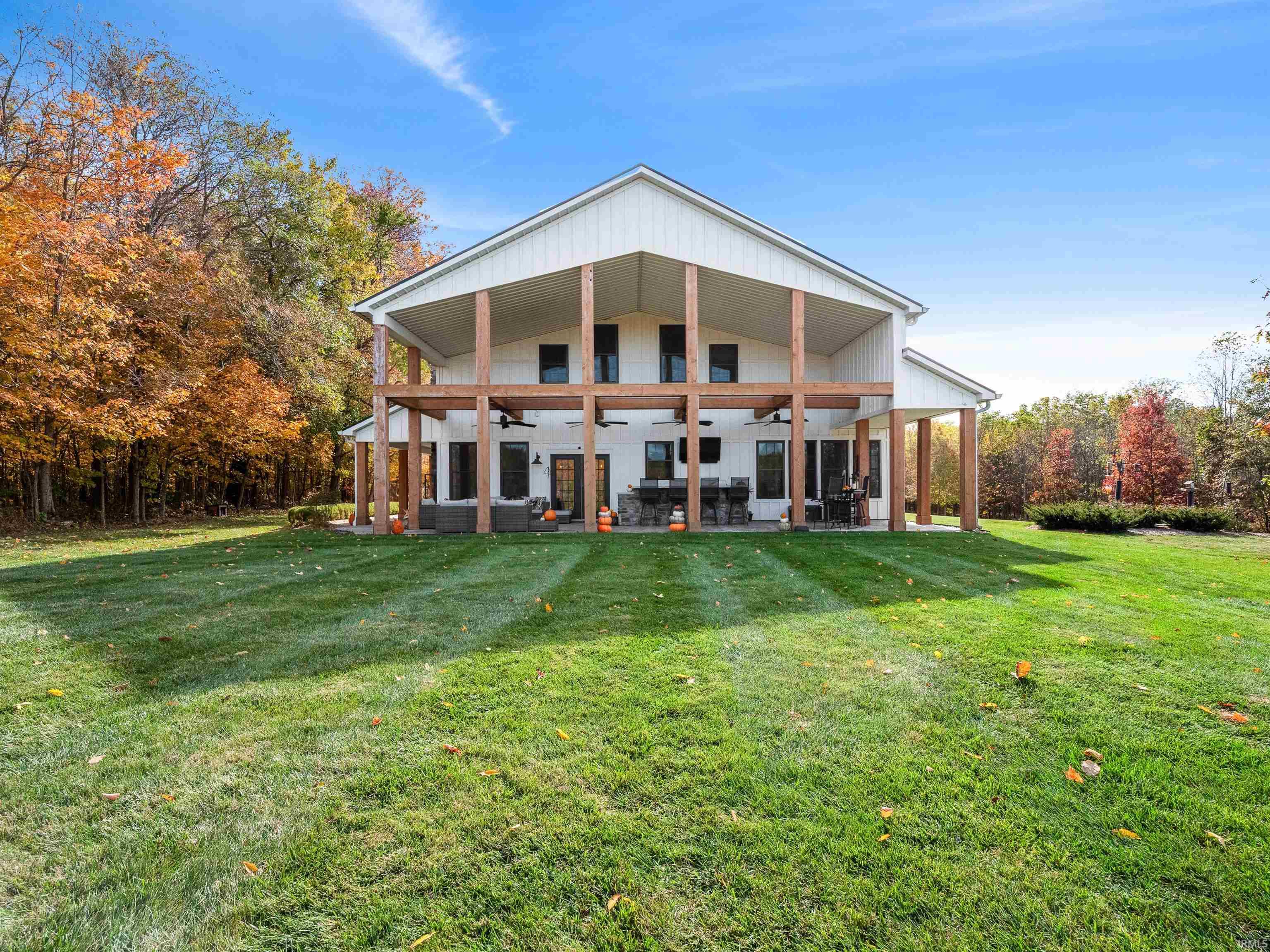 Back of house with a ceiling fan, a yard, a patio, and outdoor seating