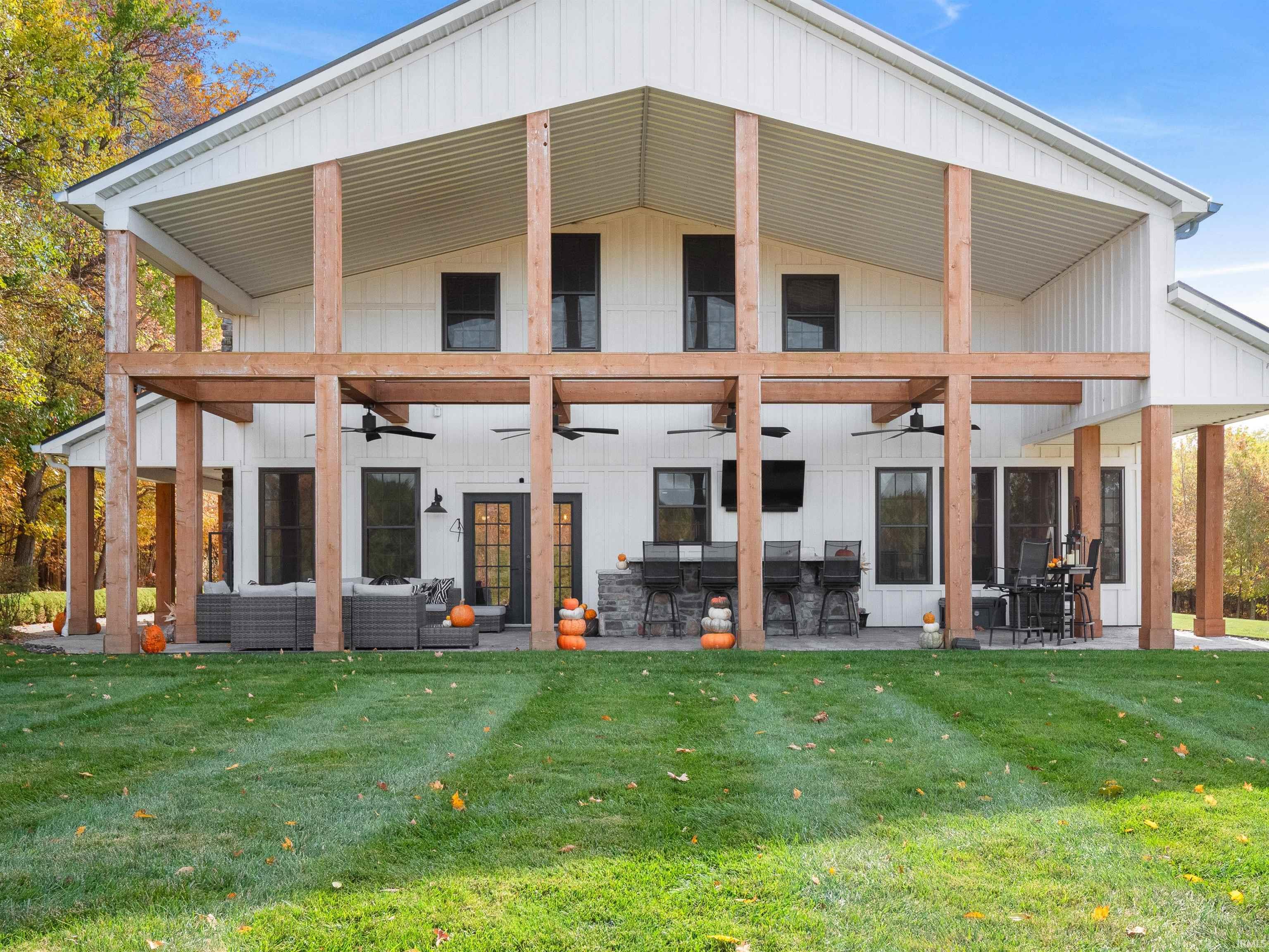 Back of property with a ceiling fan, a lawn, and an outdoor living space