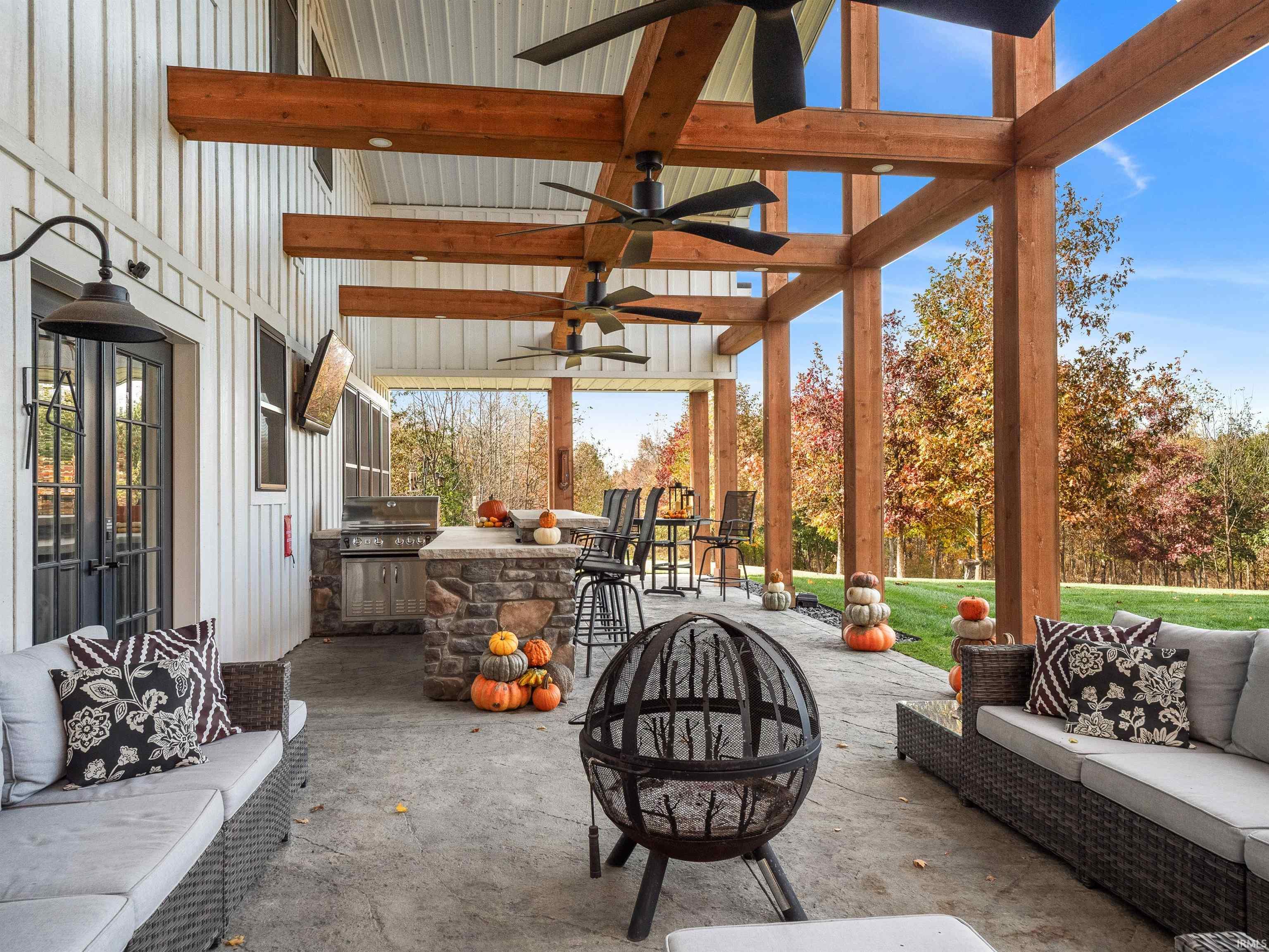 View of patio with ceiling fan, an outdoor lounge area with bar, an outdoor kitchen, french doors, and an outdoor fire pit