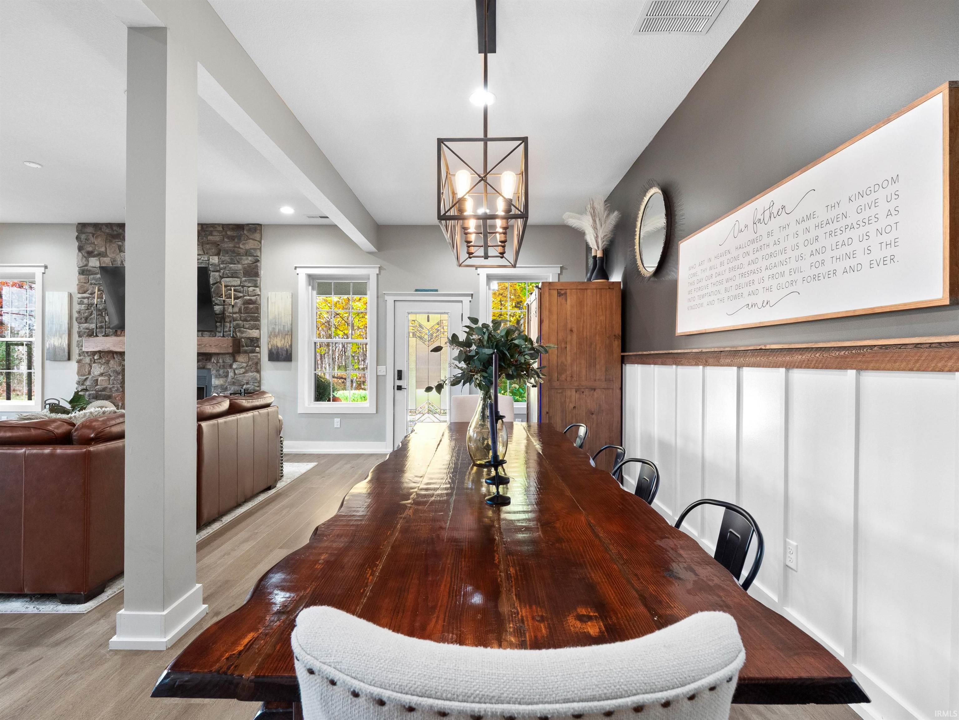 Dining area featuring light wood-style floors, a fireplace, and hanging lights