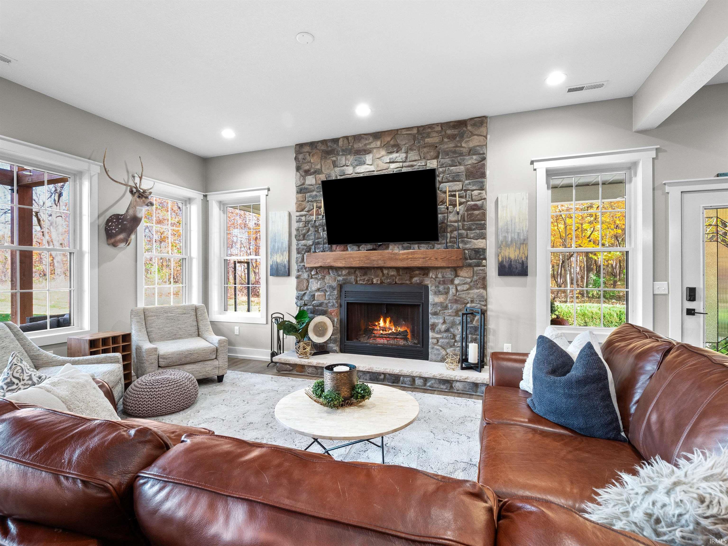 Living area featuring a stone fireplace and wood finished floors