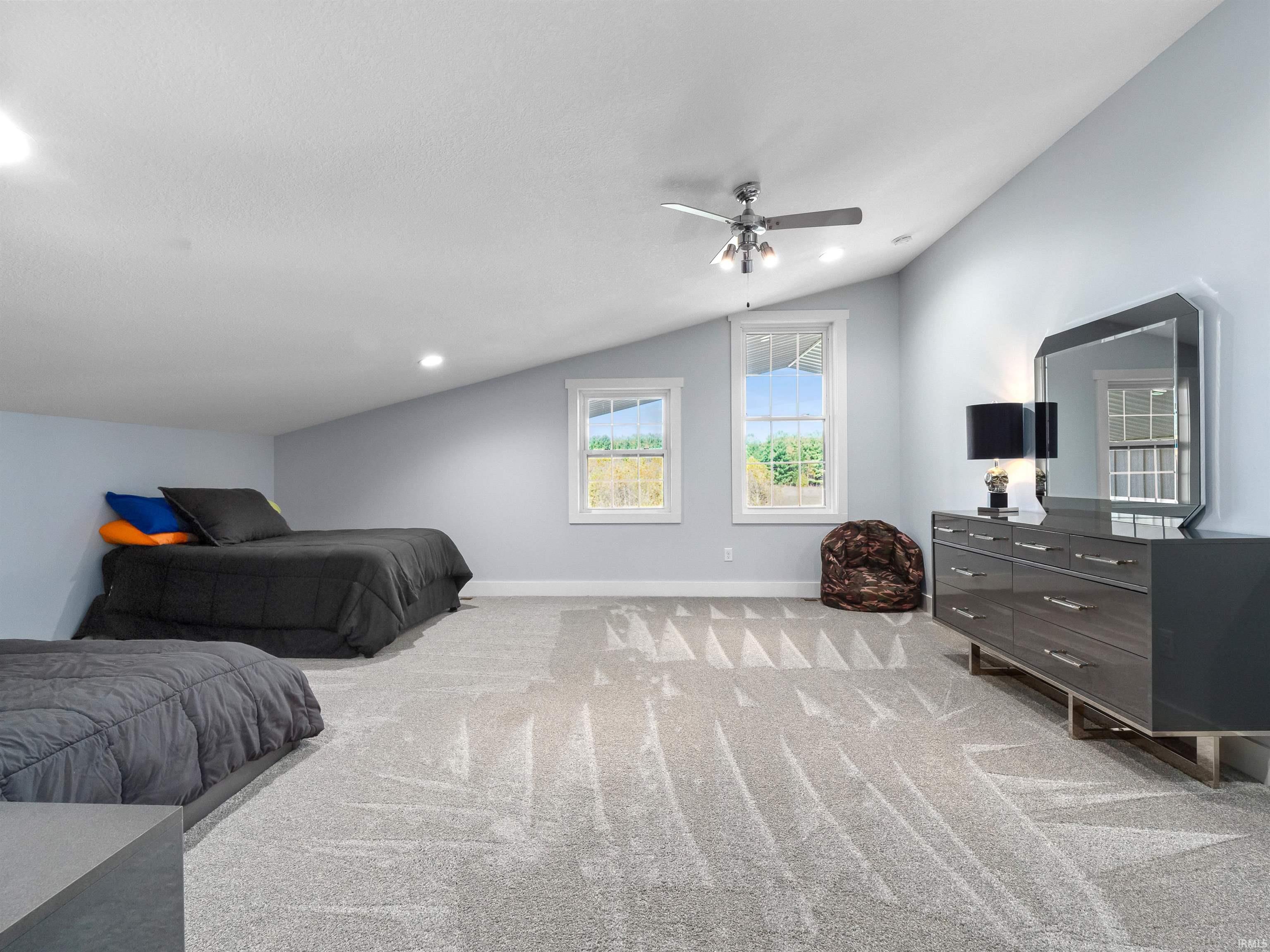 Bedroom with light colored carpet, lofted ceiling, ceiling fan, and recessed lighting