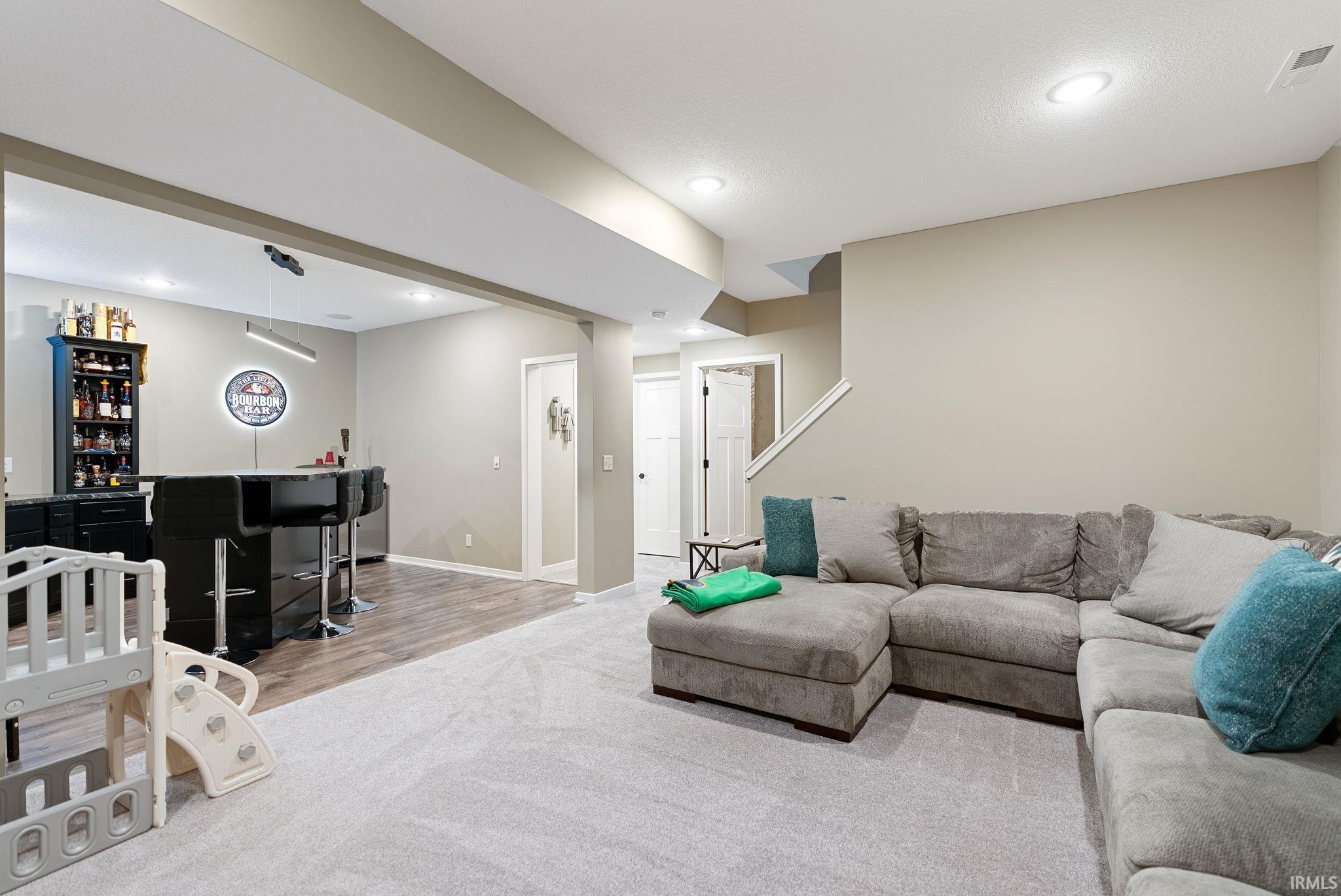 Living room featuring a dry bar, recessed lighting, and light carpet