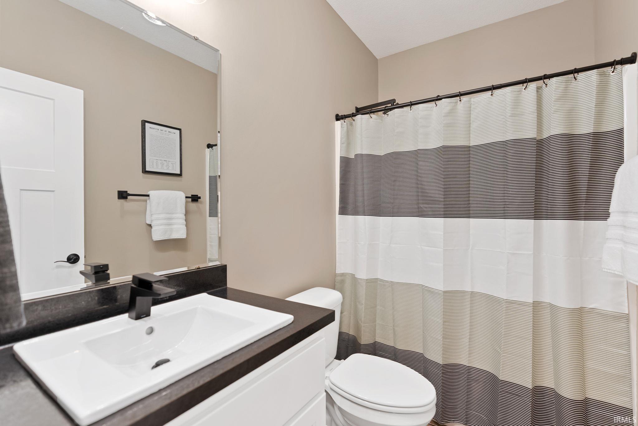 Full bathroom with vanity and curtained shower