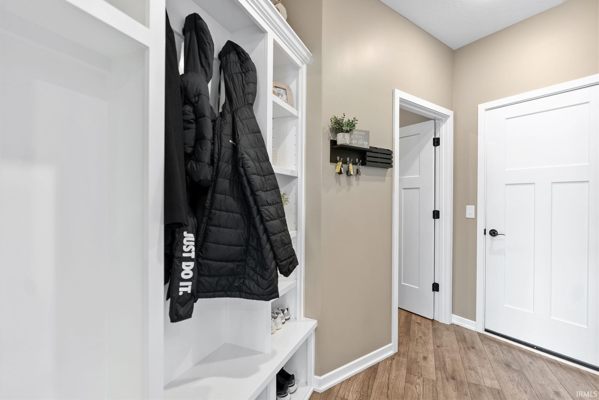 Mudroom featuring light wood finished floors and baseboards