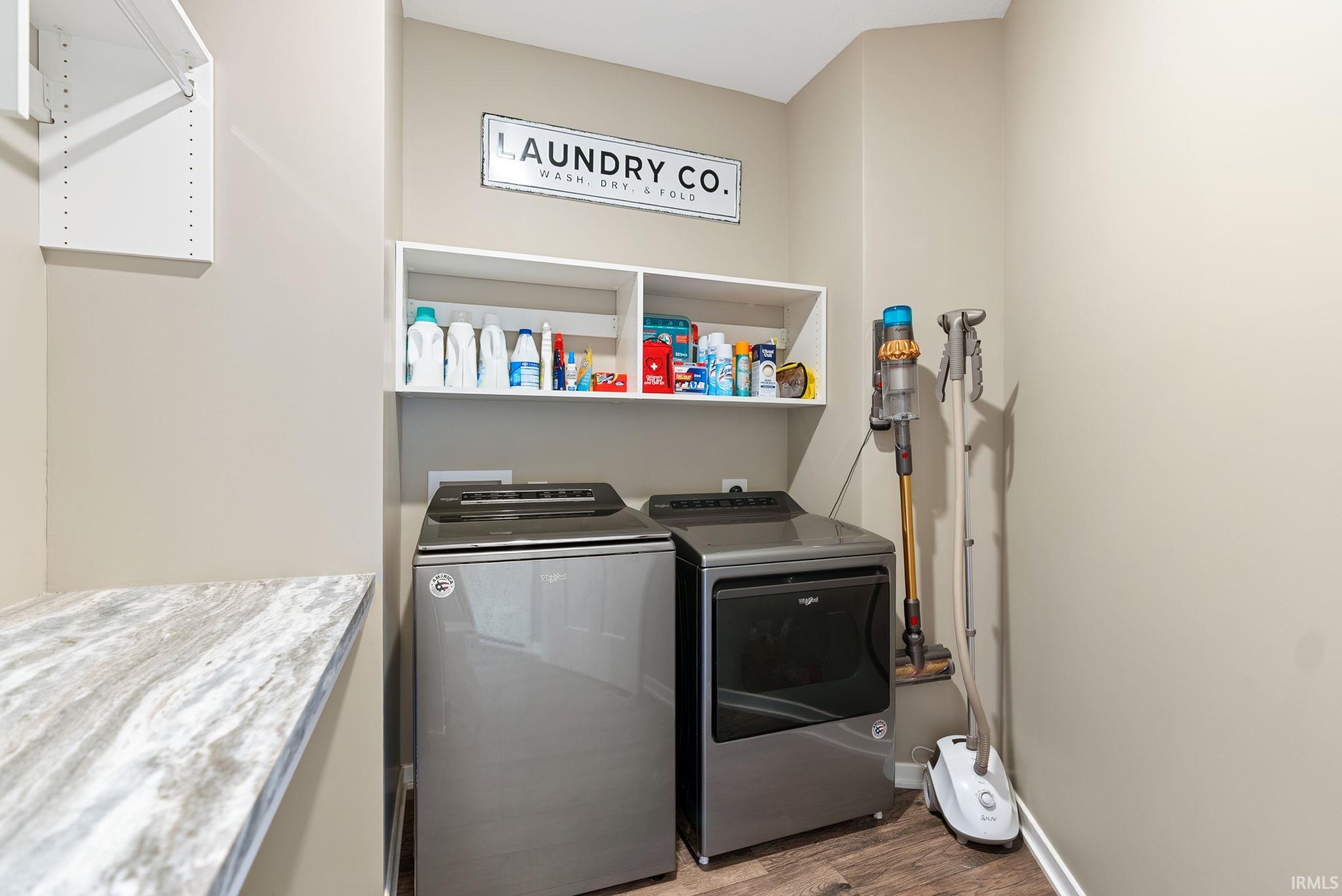 Laundry room featuring dark wood-type flooring and separate washer and dryer