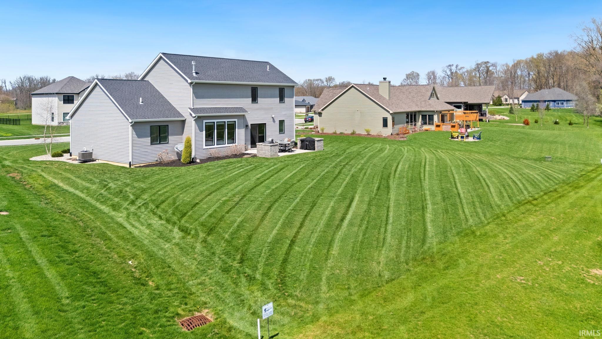 Back of property featuring a patio area, a yard, and a shingled roof