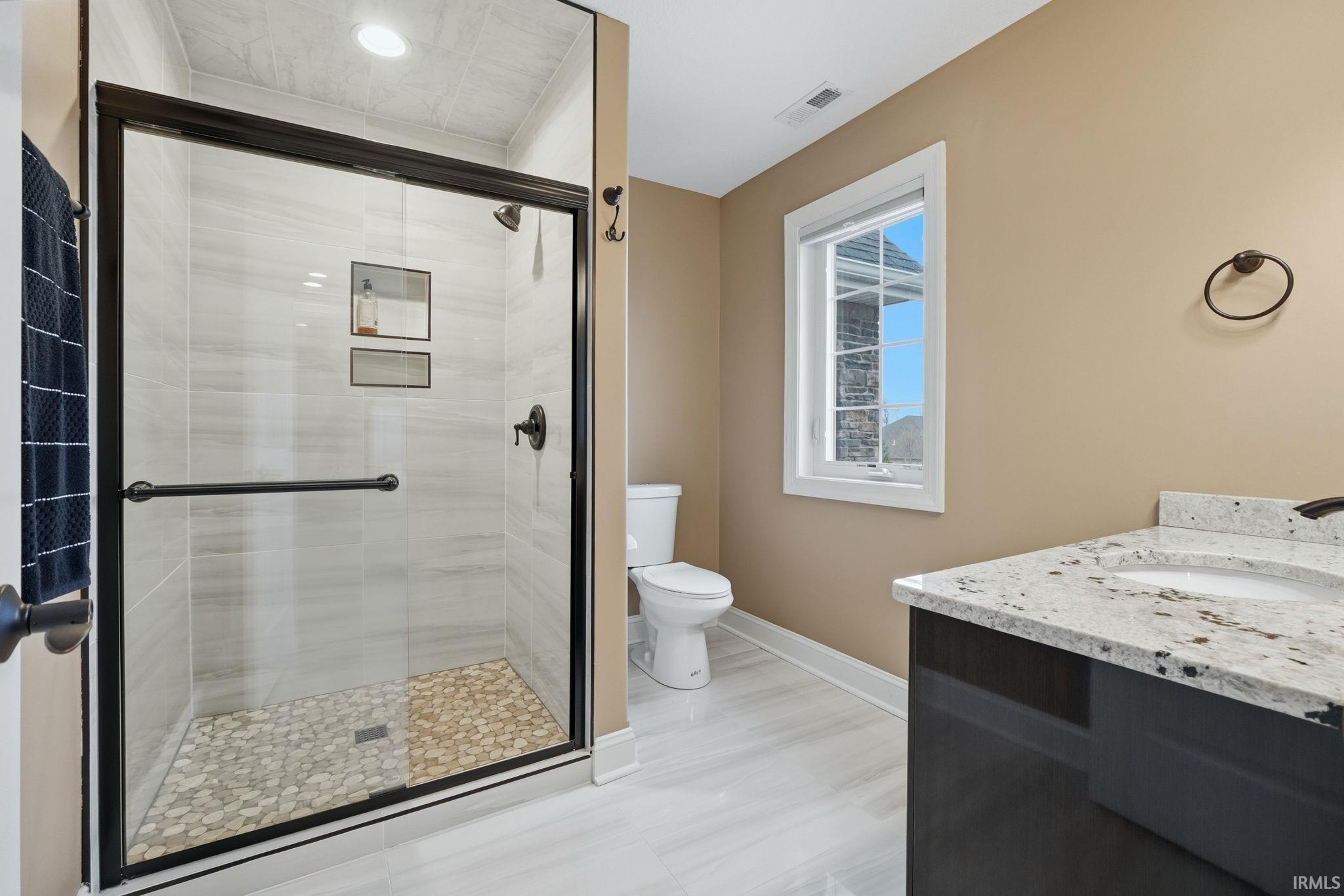 Full bath with vanity and a shower stall