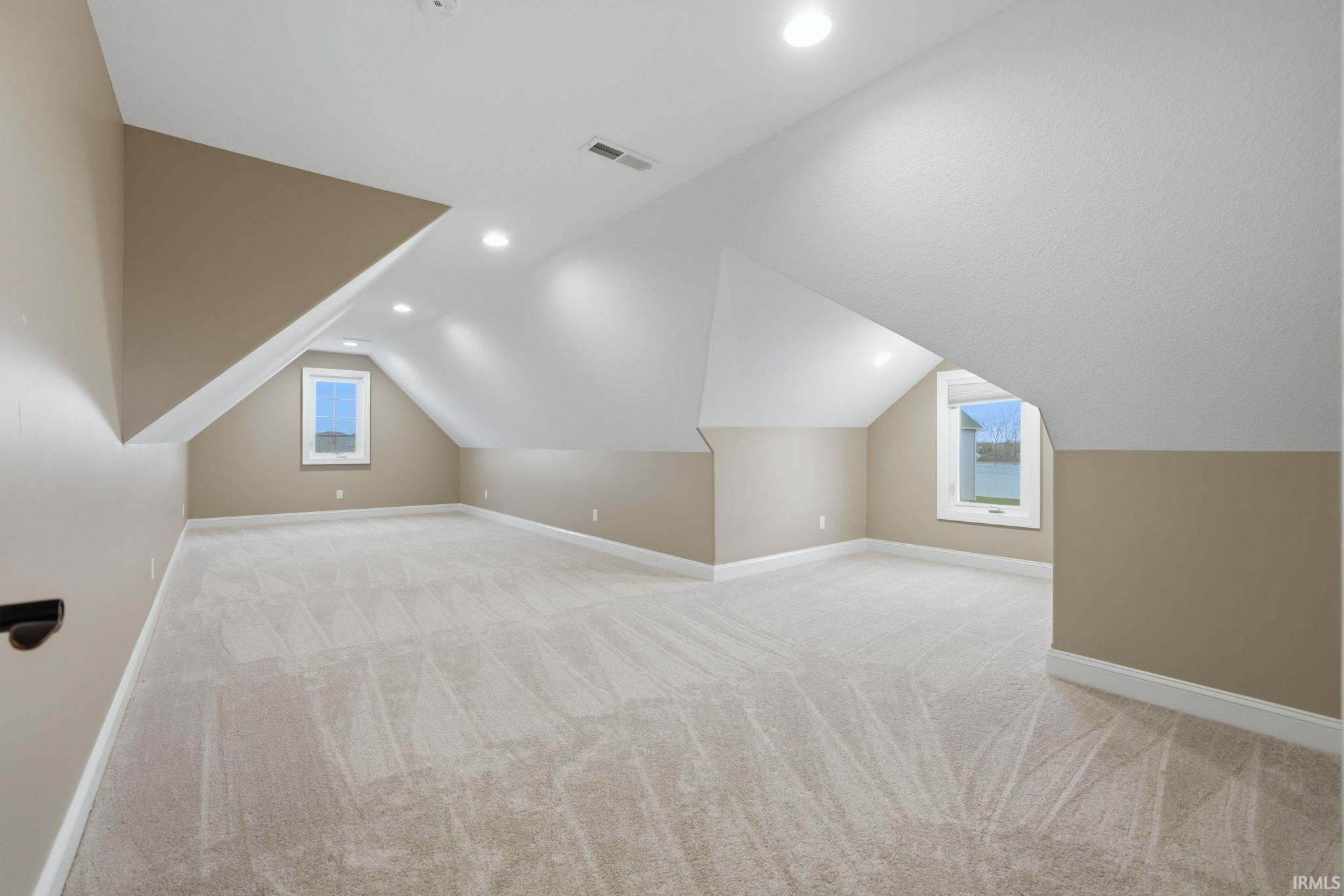 Additional living space featuring light colored carpet, lofted ceiling, and recessed lighting
