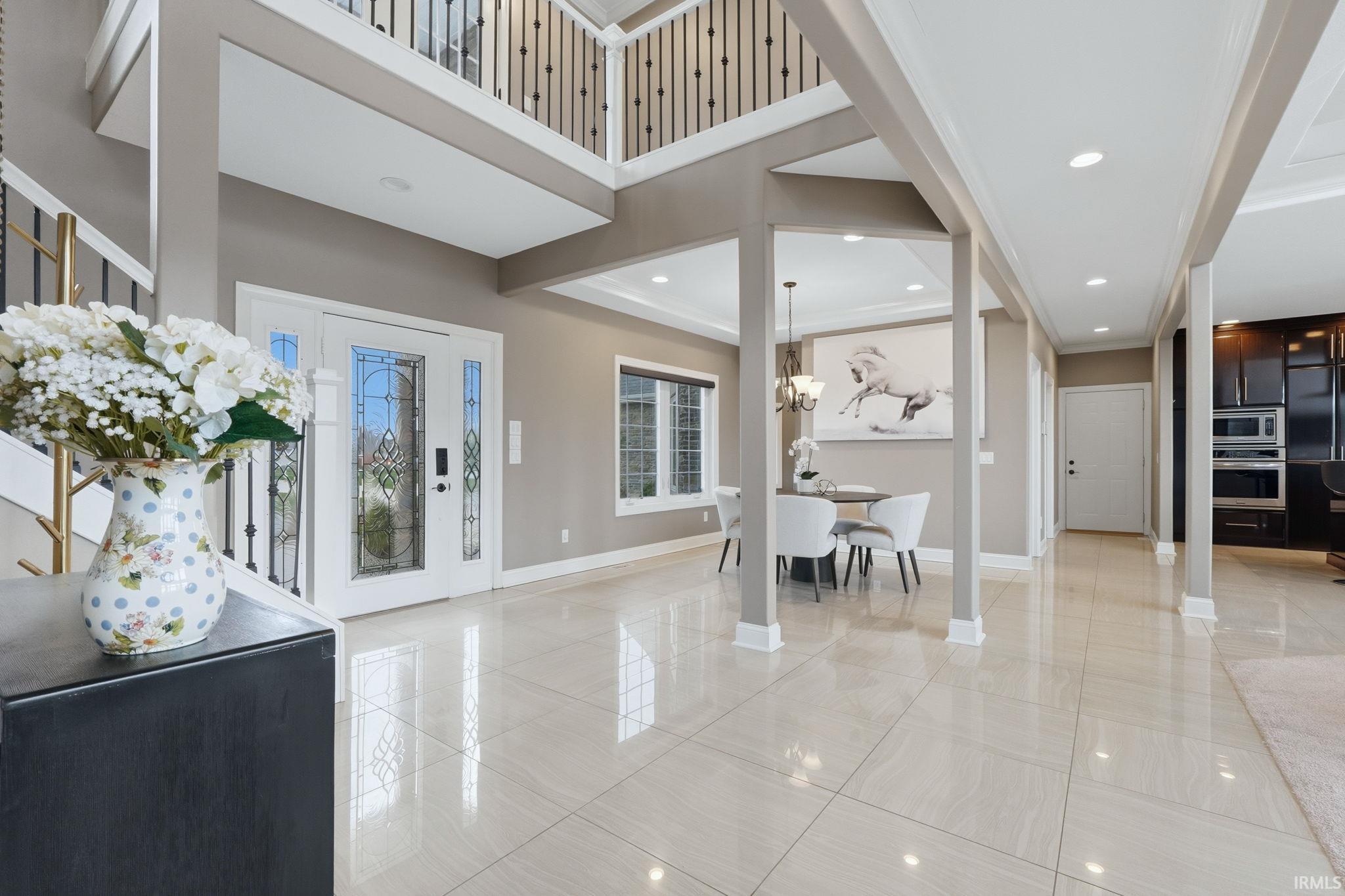Entryway with recessed lighting, a high ceiling, and ornamental molding