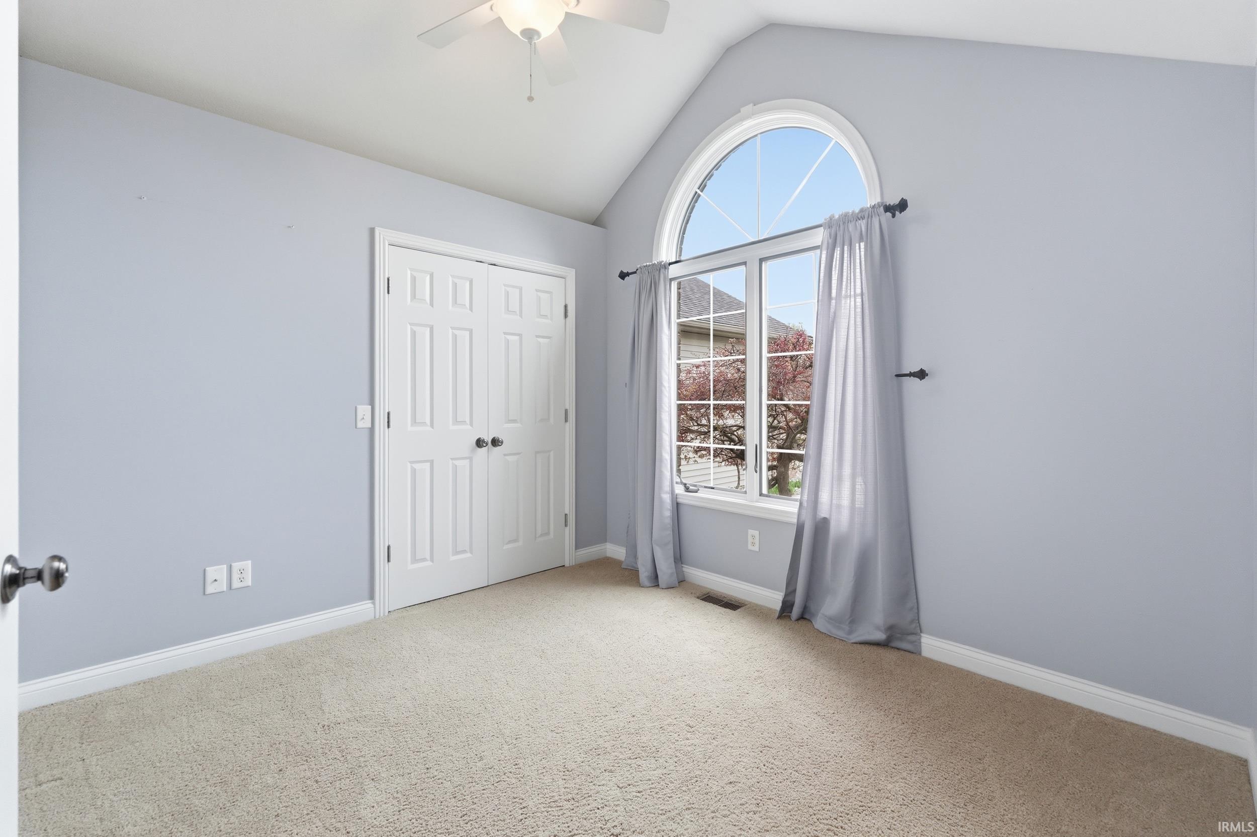 Unfurnished bedroom with light carpet, a ceiling fan, and a closet