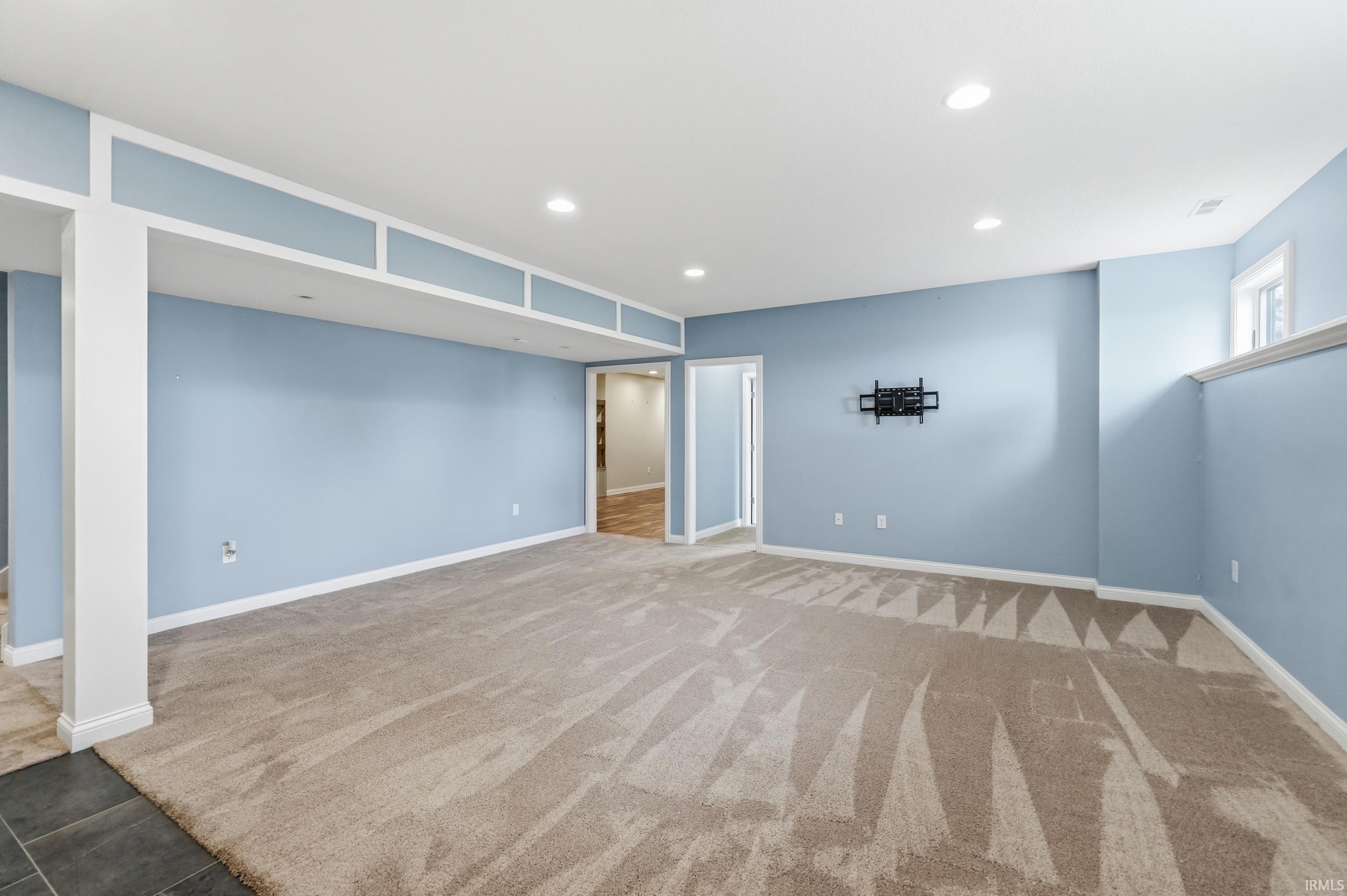 Below grade area featuring recessed lighting and light carpet