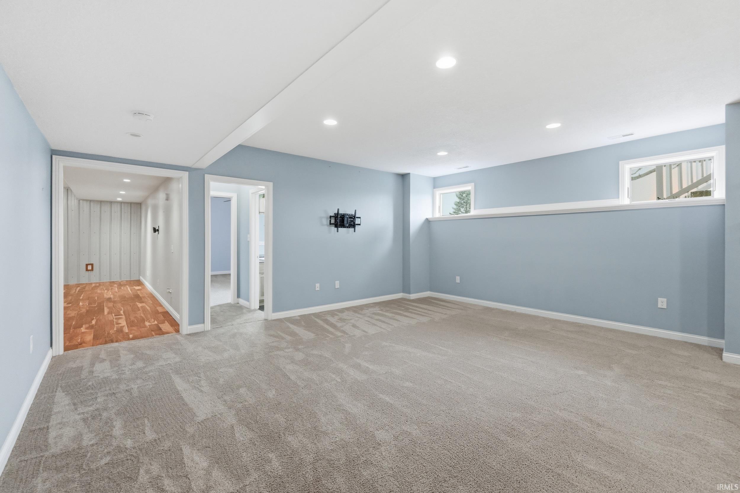 Basement with light carpet and recessed lighting