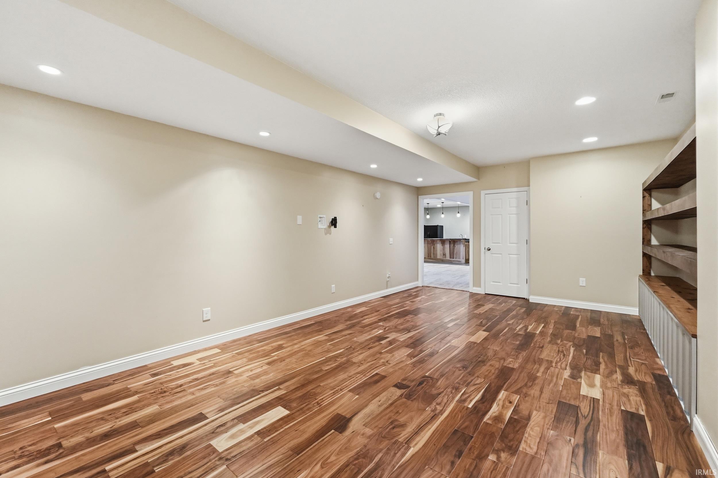 Finished below grade area with dark wood-style floors and recessed lighting