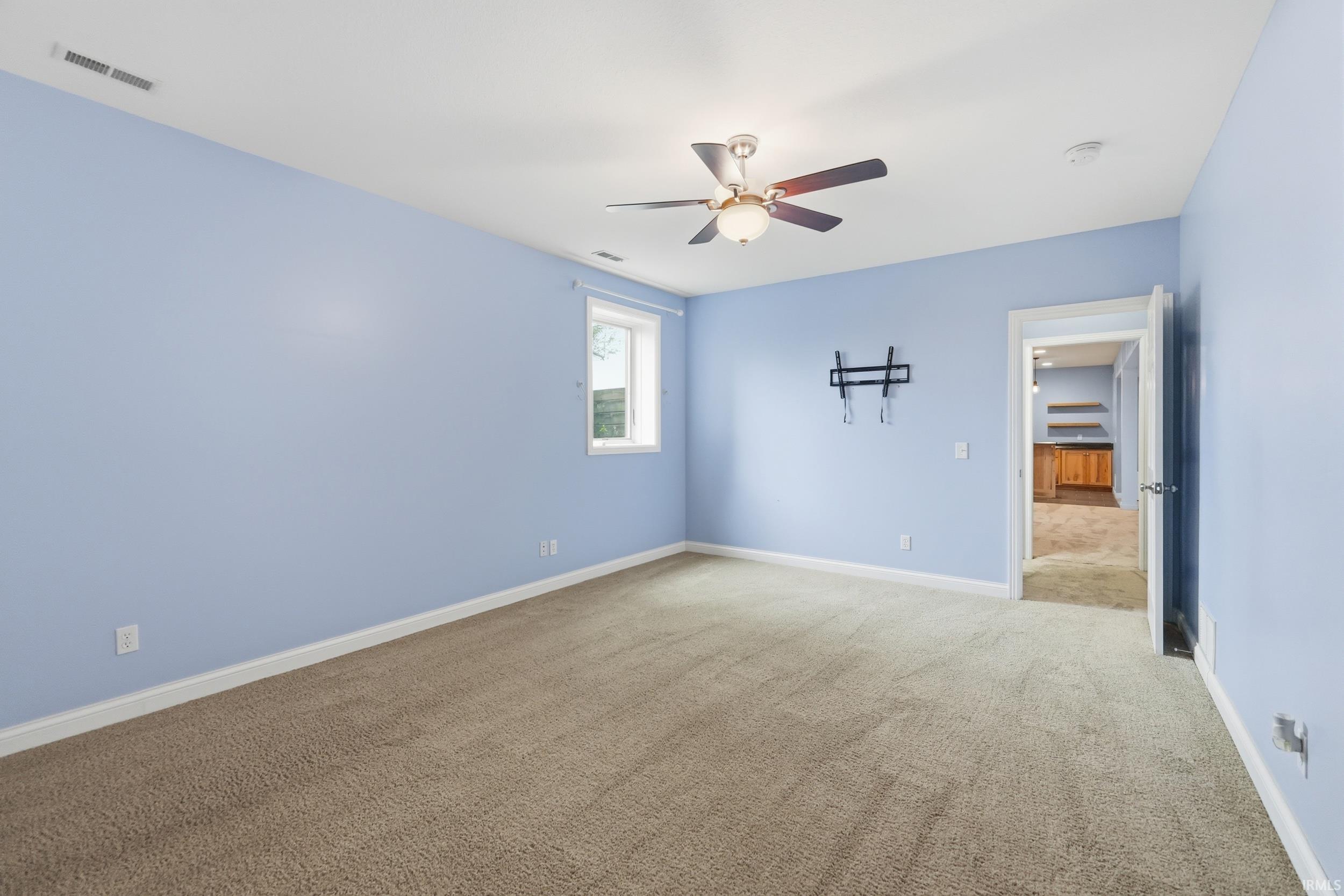 Unfurnished bedroom featuring light colored carpet and a ceiling fan