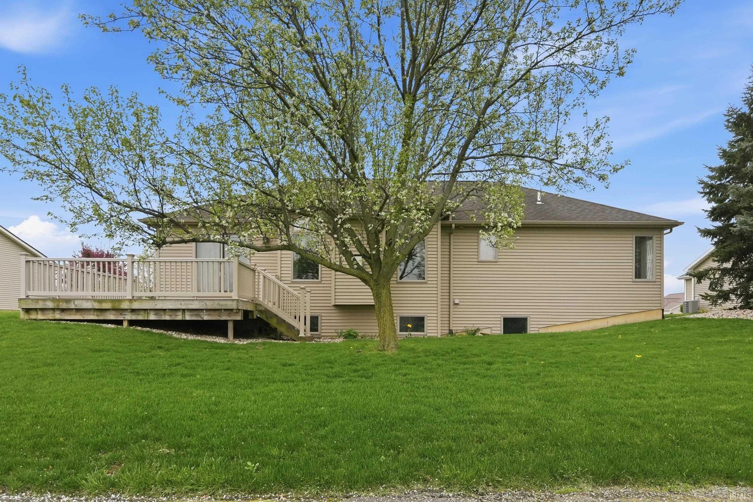 Rear view of property featuring a wooden deck and a yard