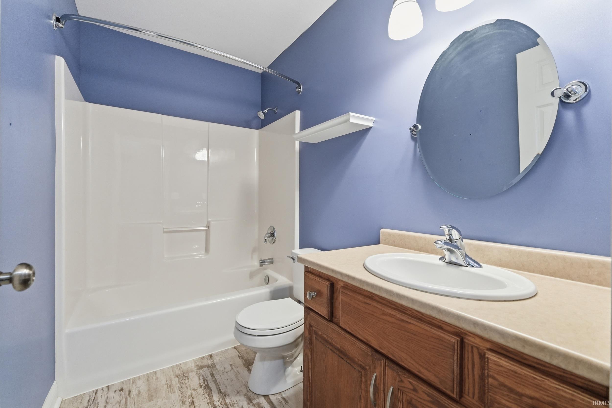 Full bathroom featuring vanity, light wood-style flooring, and  shower combination
