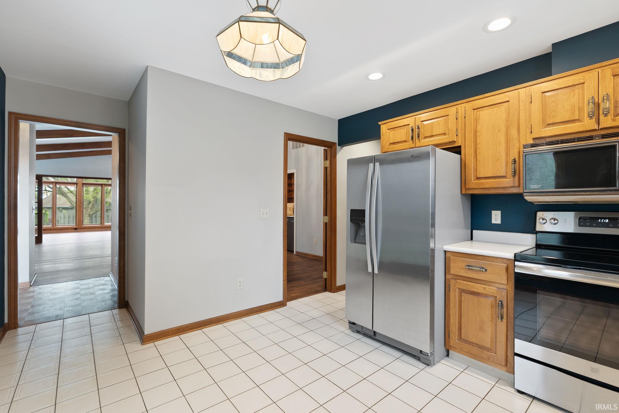 Kitchen featuring stainless steel appliances, light countertops, light tile patterned floors, and recessed lighting
