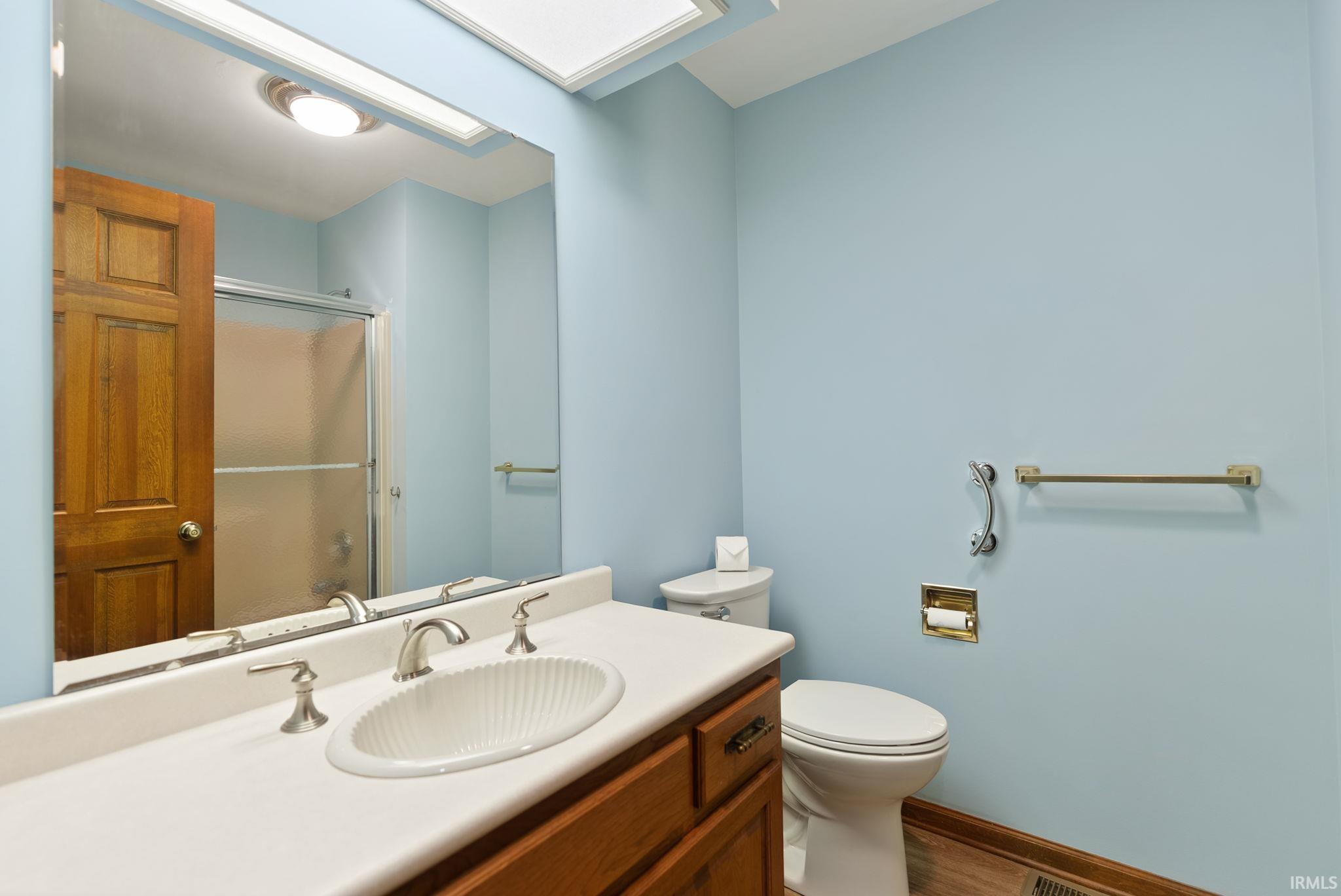 Full bathroom featuring vanity, a shower stall, and wood finished floors