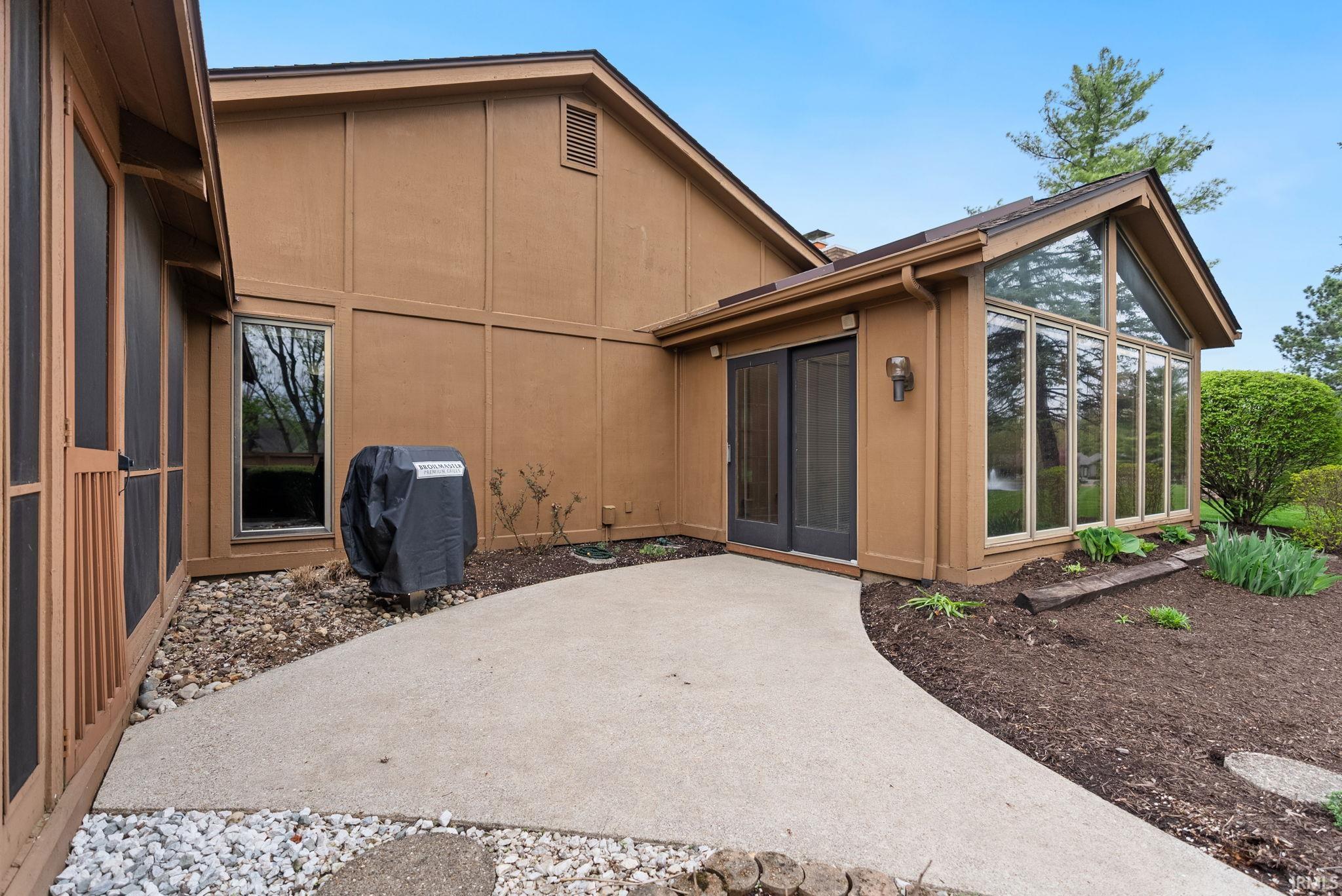 Rear view of house featuring a sunroom and a patio