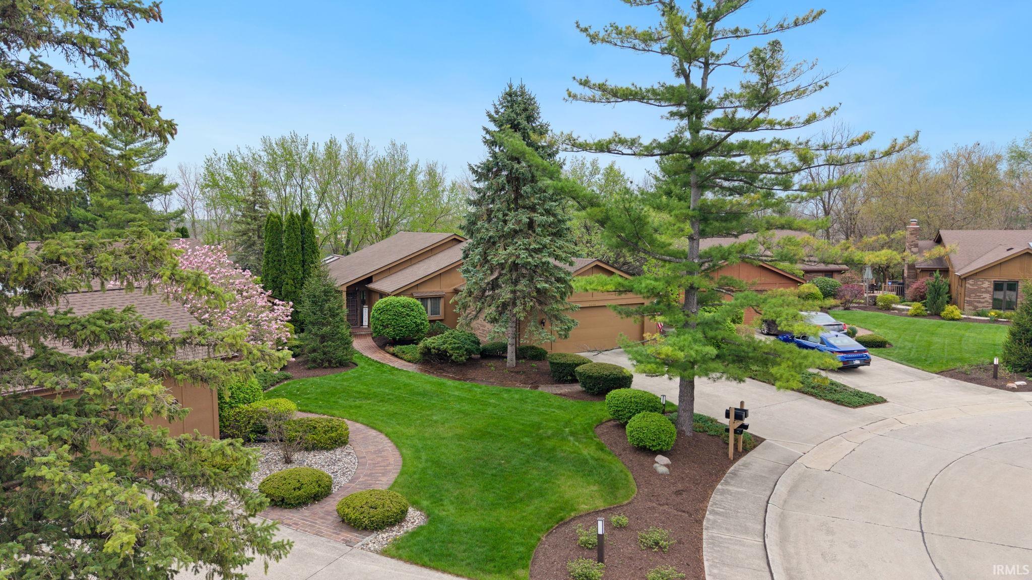 View of front of house featuring a front lawn, driveway, and a garage