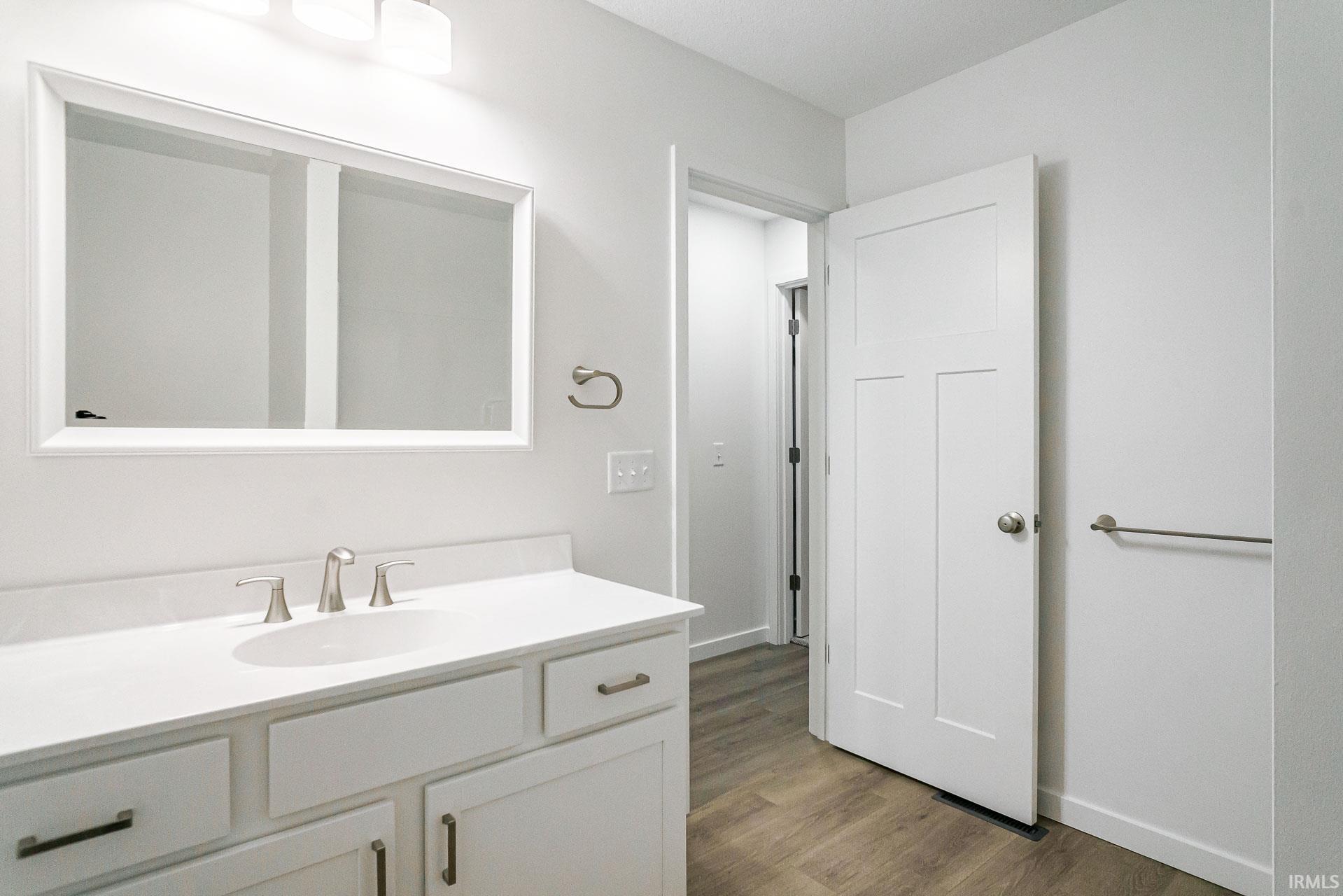 Bathroom featuring vanity and dark wood finished floors