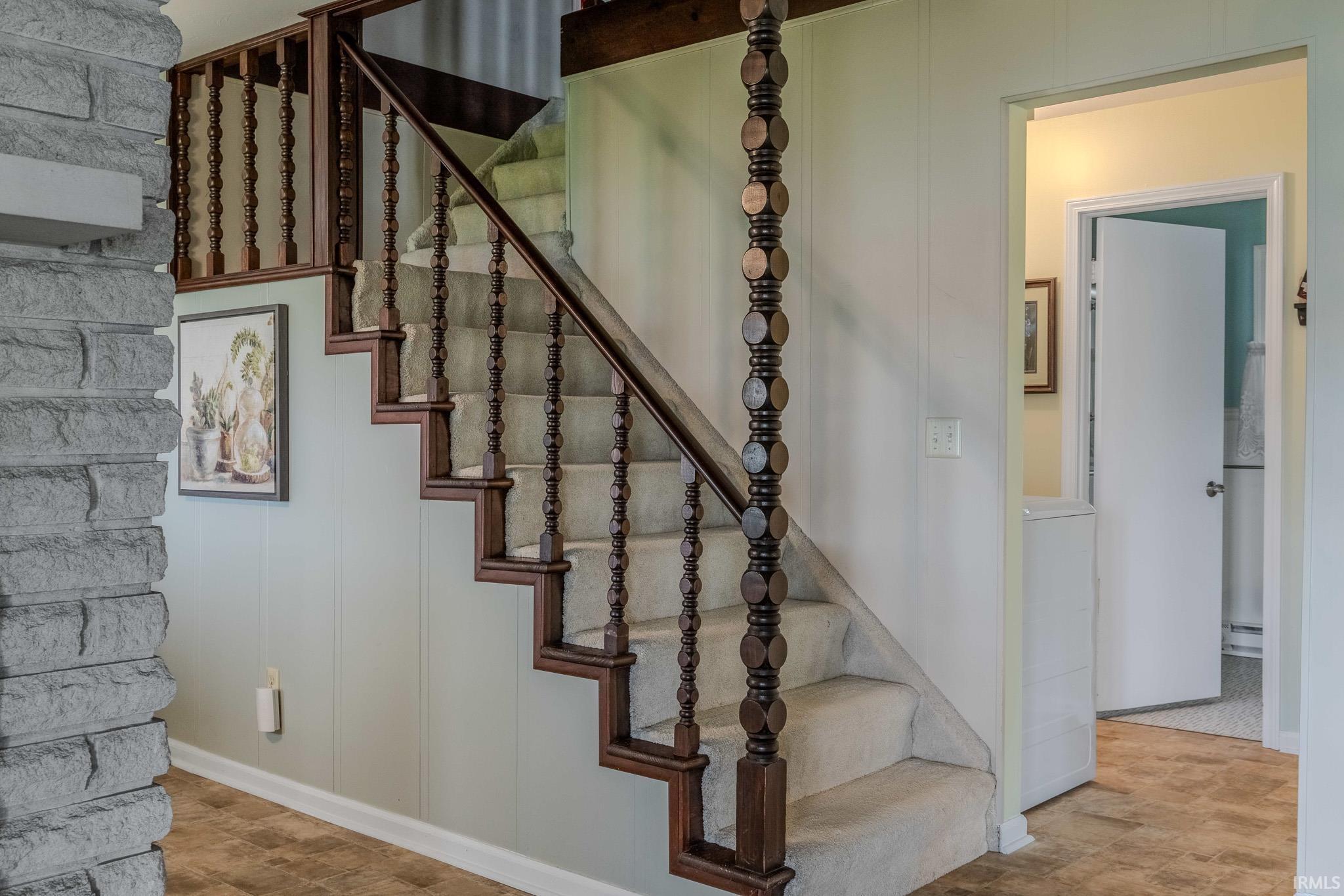 Staircase featuring a decorative wall