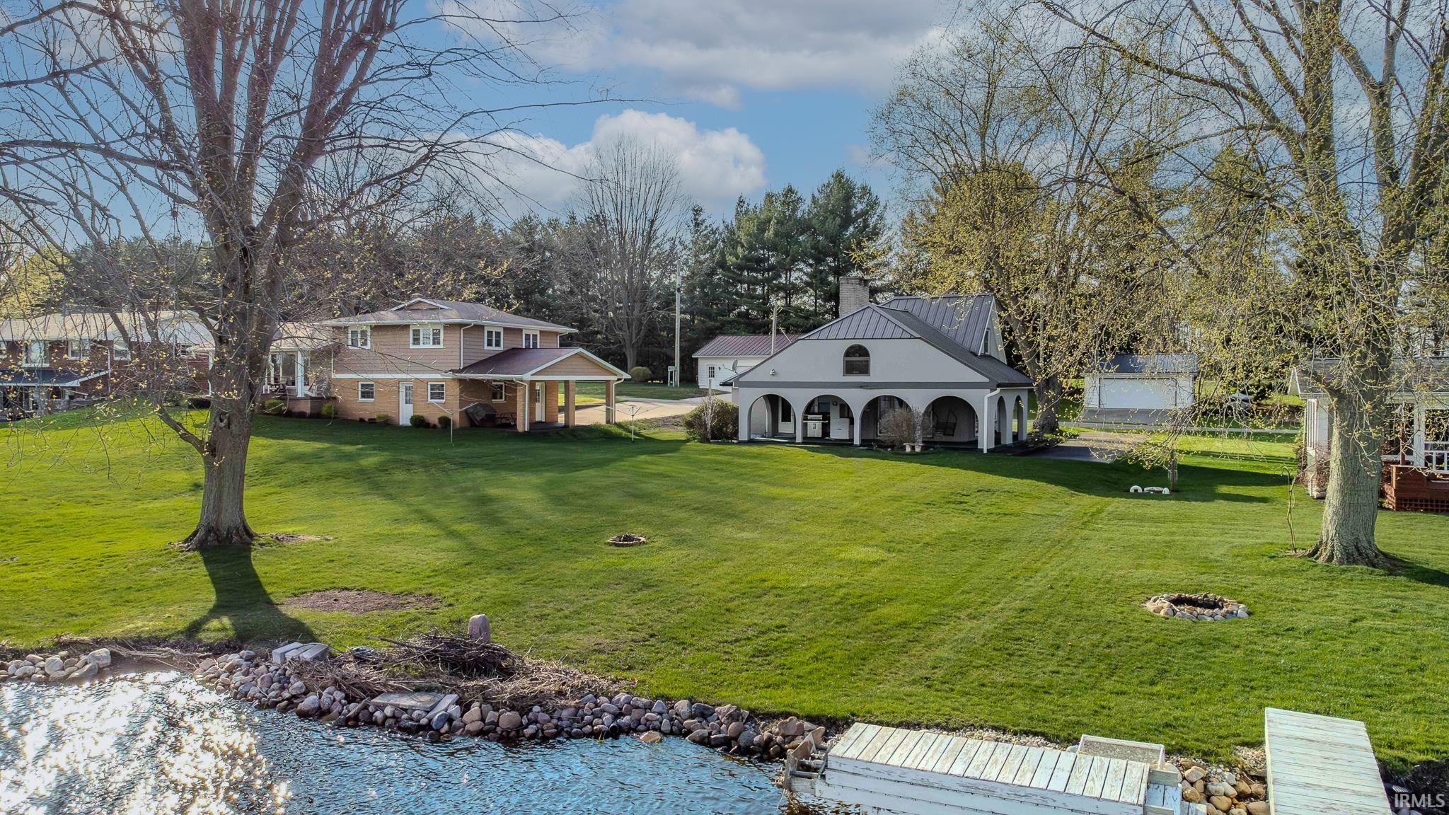 View of grassy yard featuring a water view and view of wooded area
