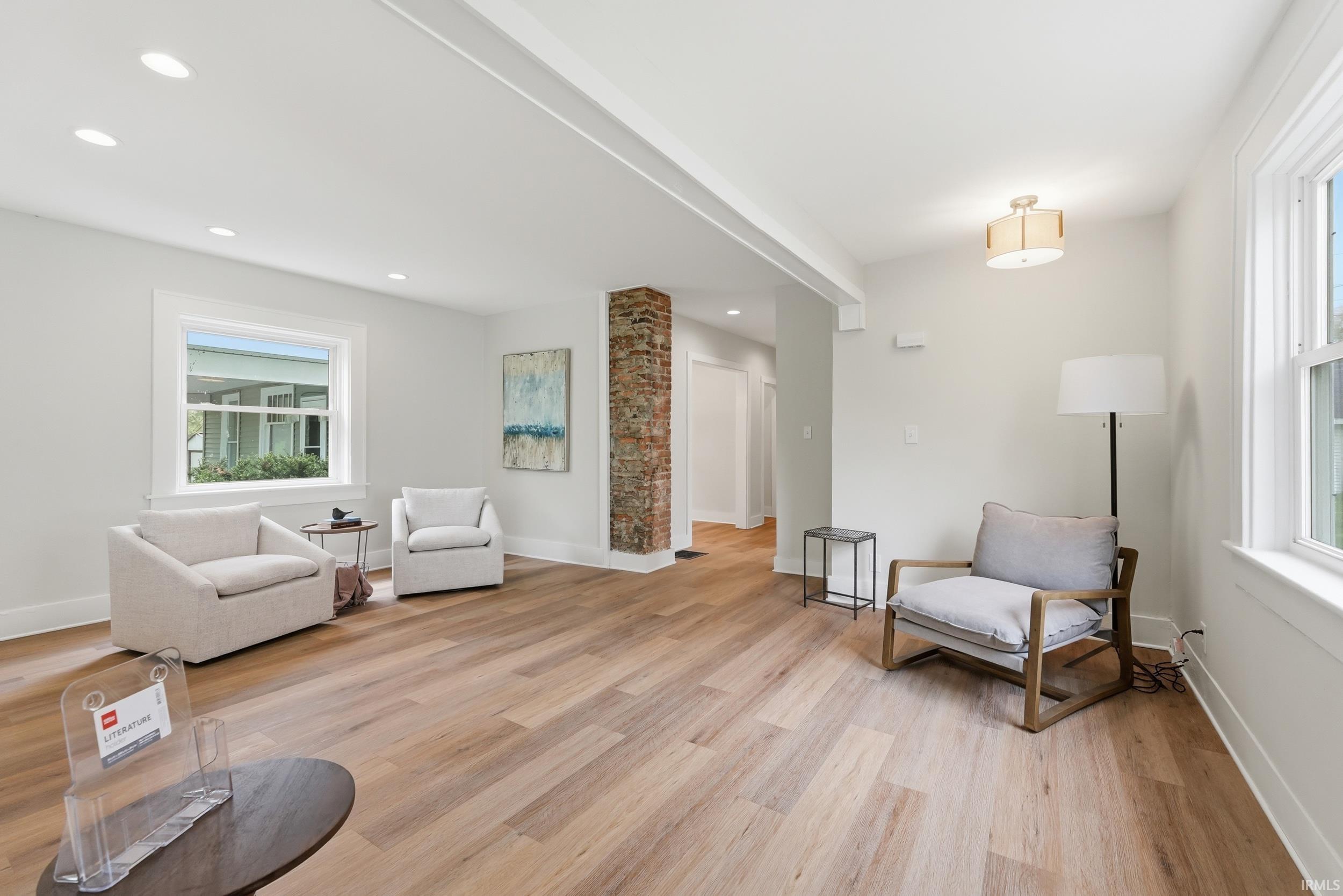 Living area featuring light wood-style floors, recessed lighting, and beam ceiling