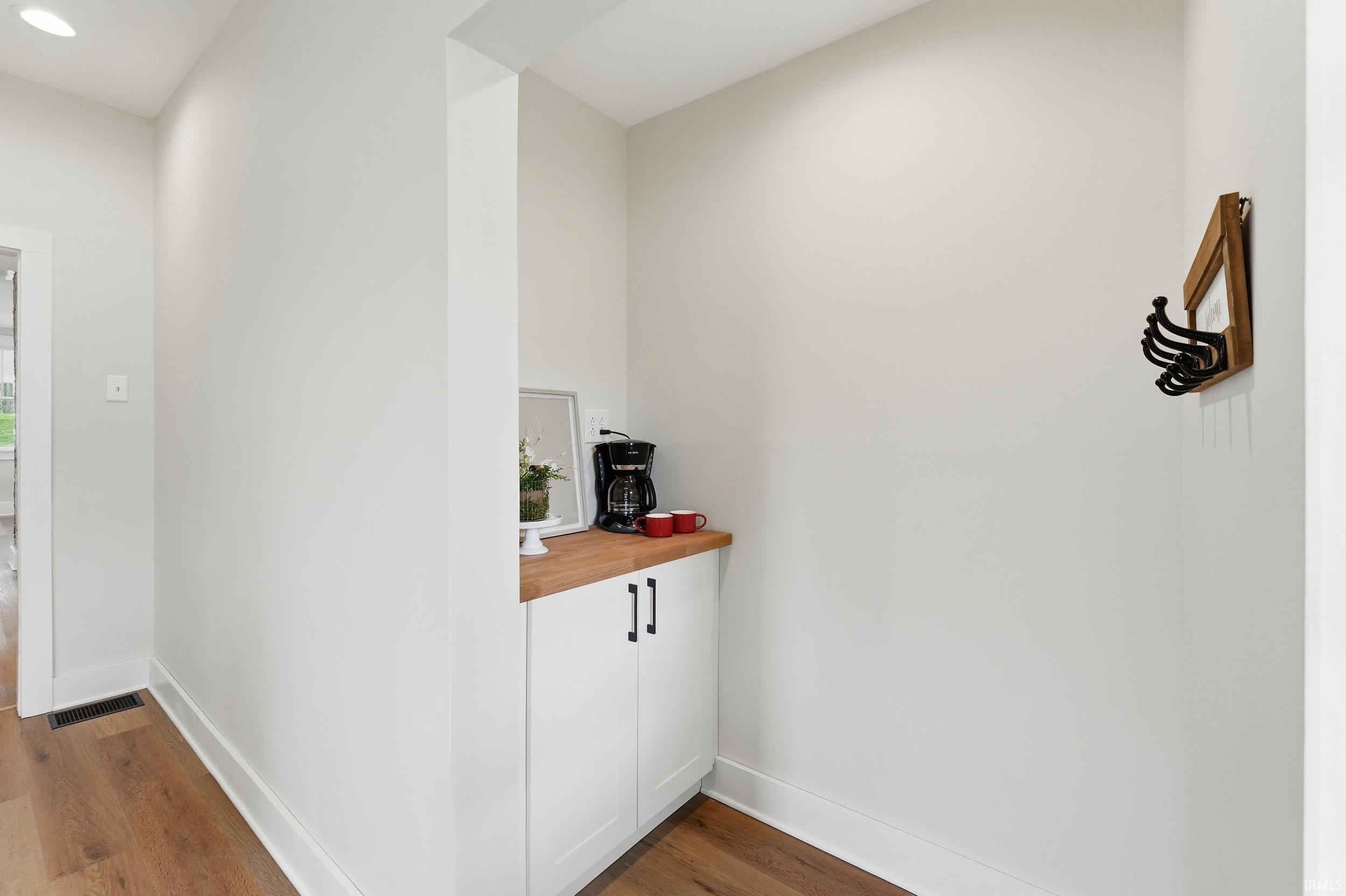 Hall with dark wood-style floors and baseboards