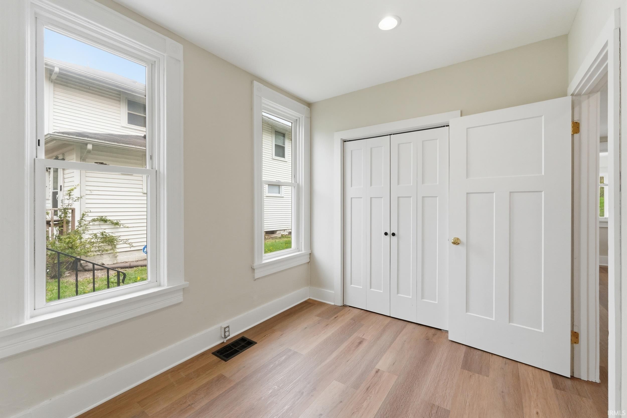 Unfurnished bedroom featuring light wood-style flooring and a closet