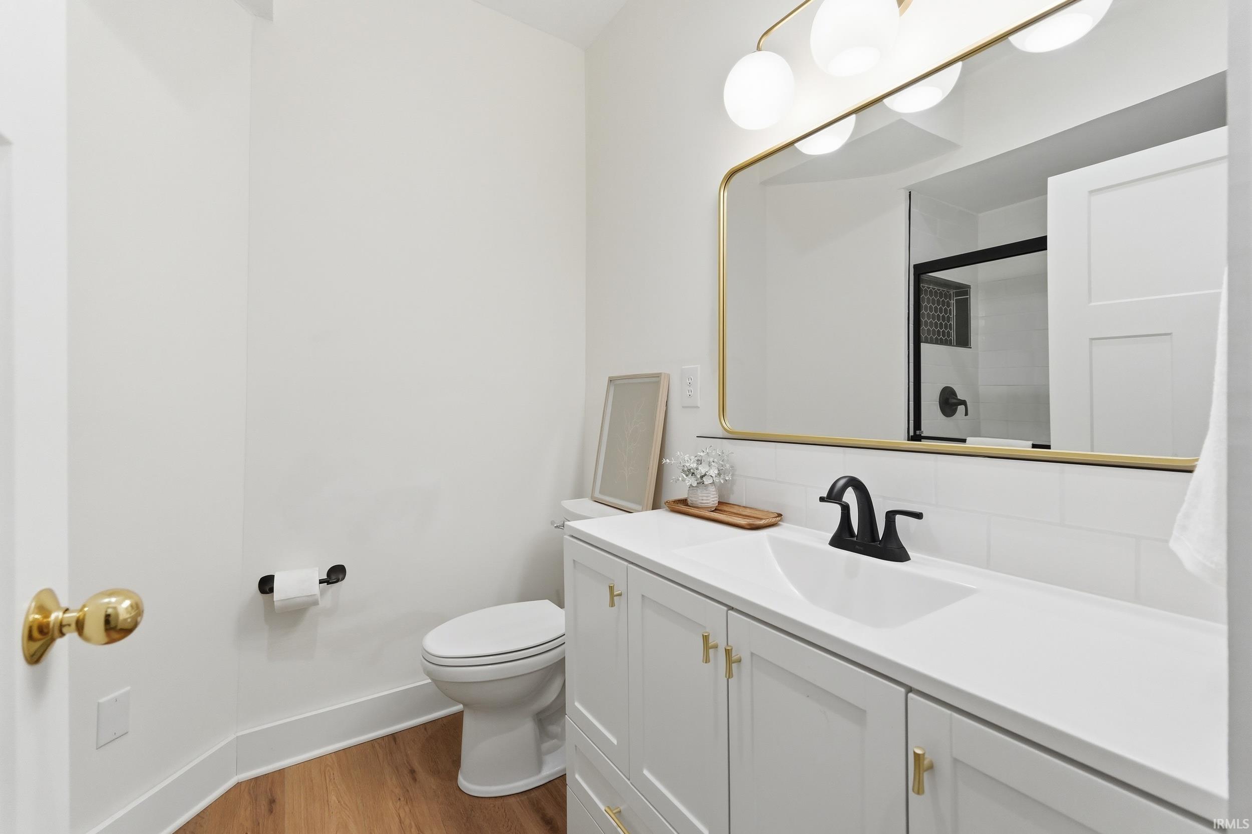 Bathroom with vanity, dark wood finished floors, and an enclosed shower