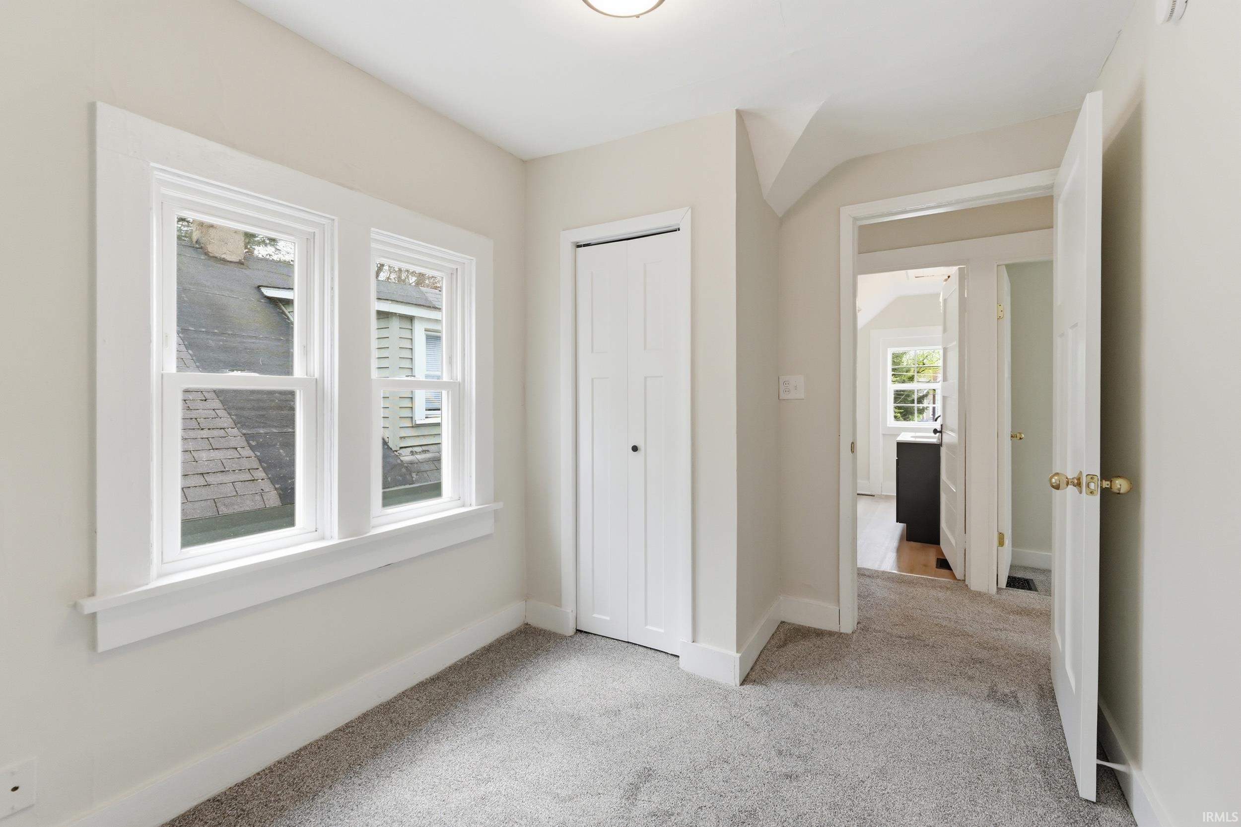 Unfurnished bedroom with light carpet and a closet