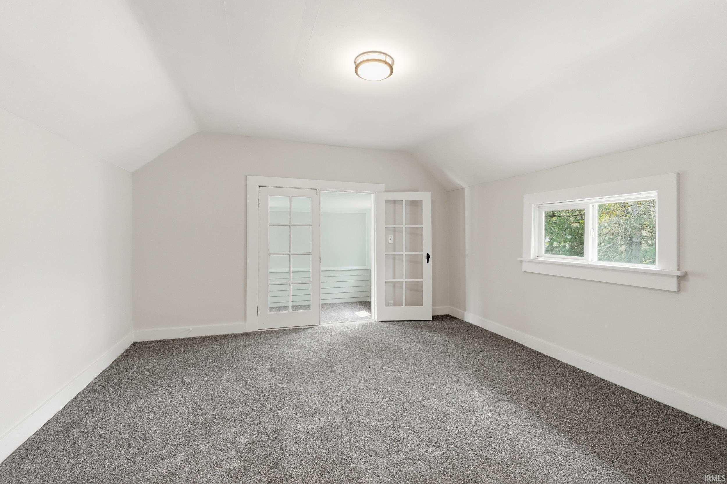 Additional living space with lofted ceiling and carpet