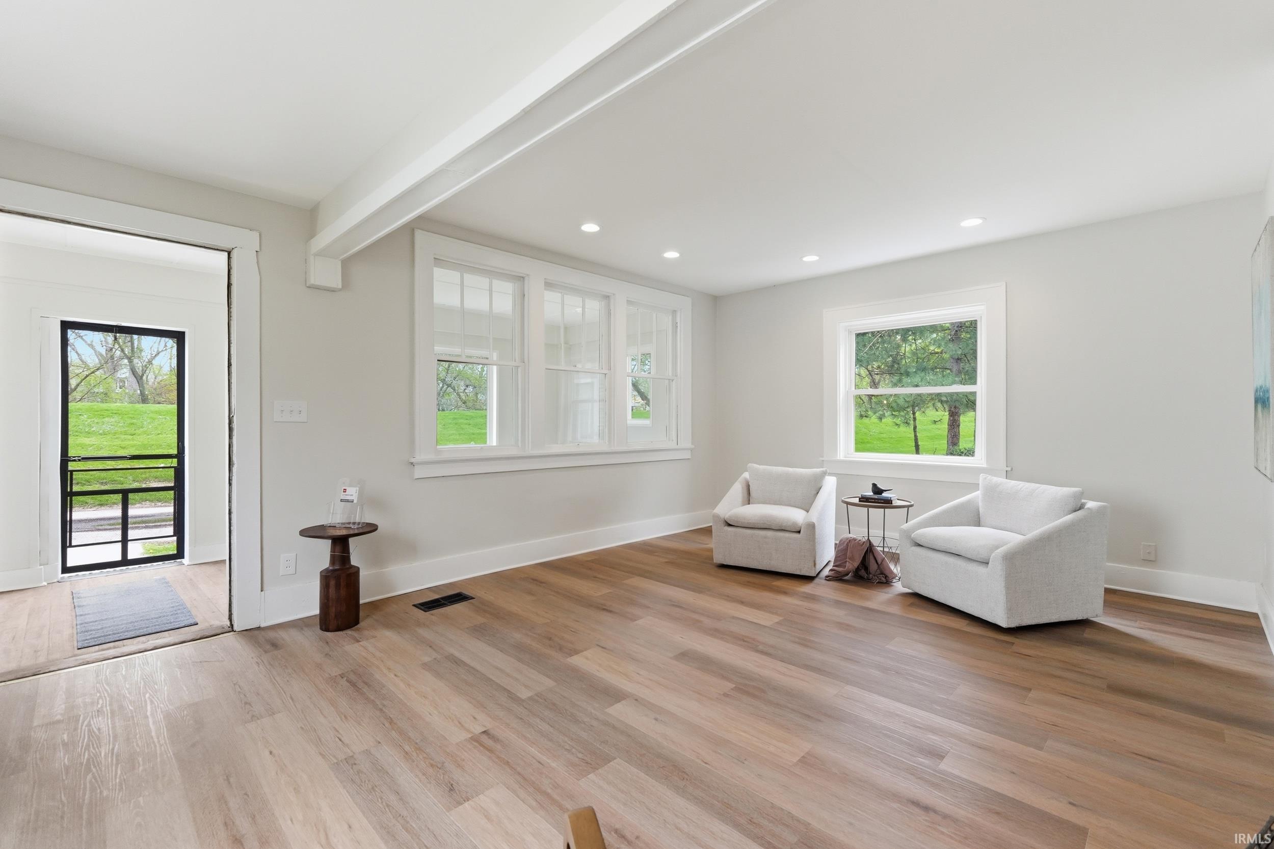 Sitting room featuring light wood-type flooring, beam ceiling, and recessed lighting