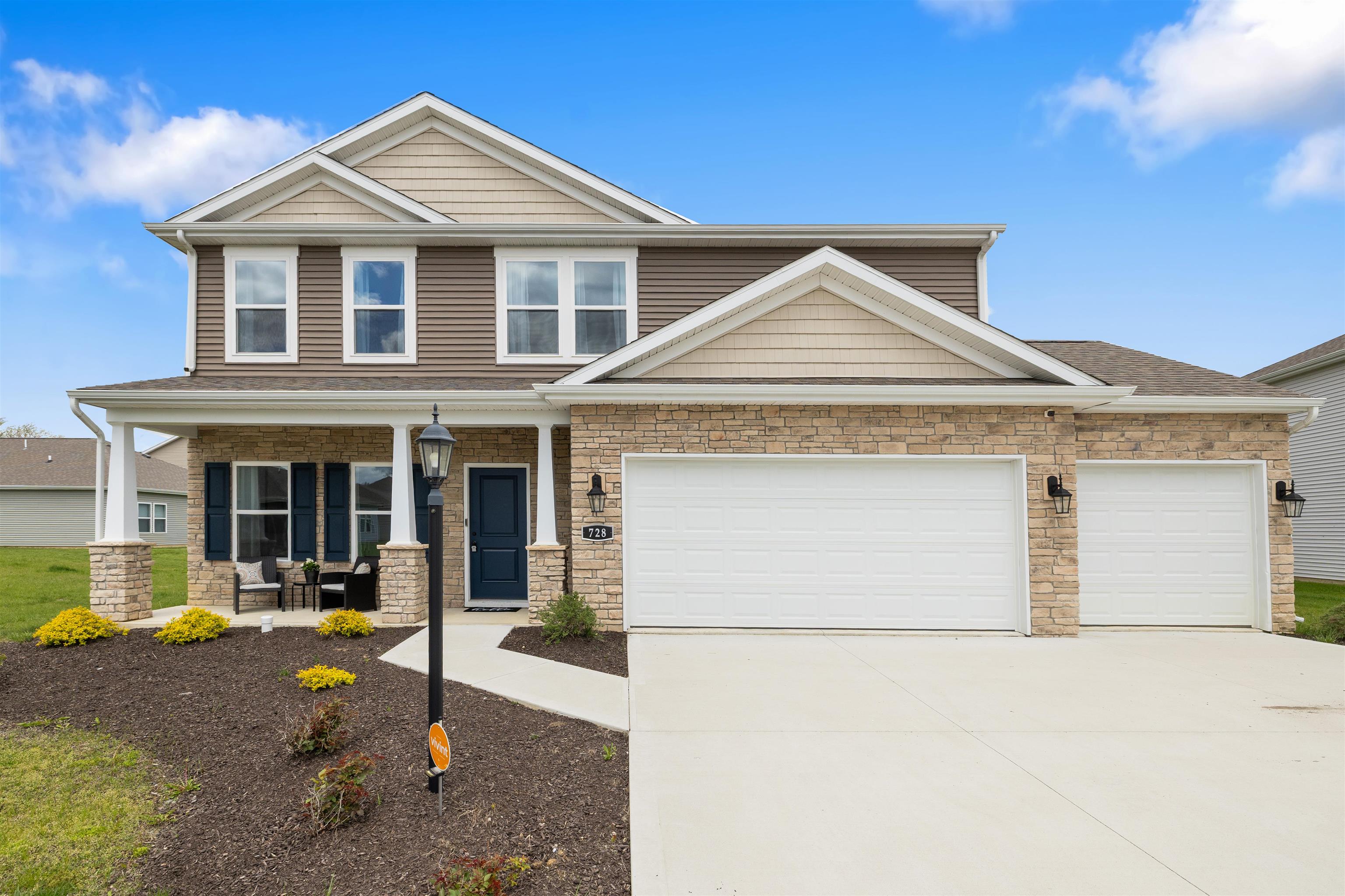 Two-story home with stone veneer and horizontal siding facade