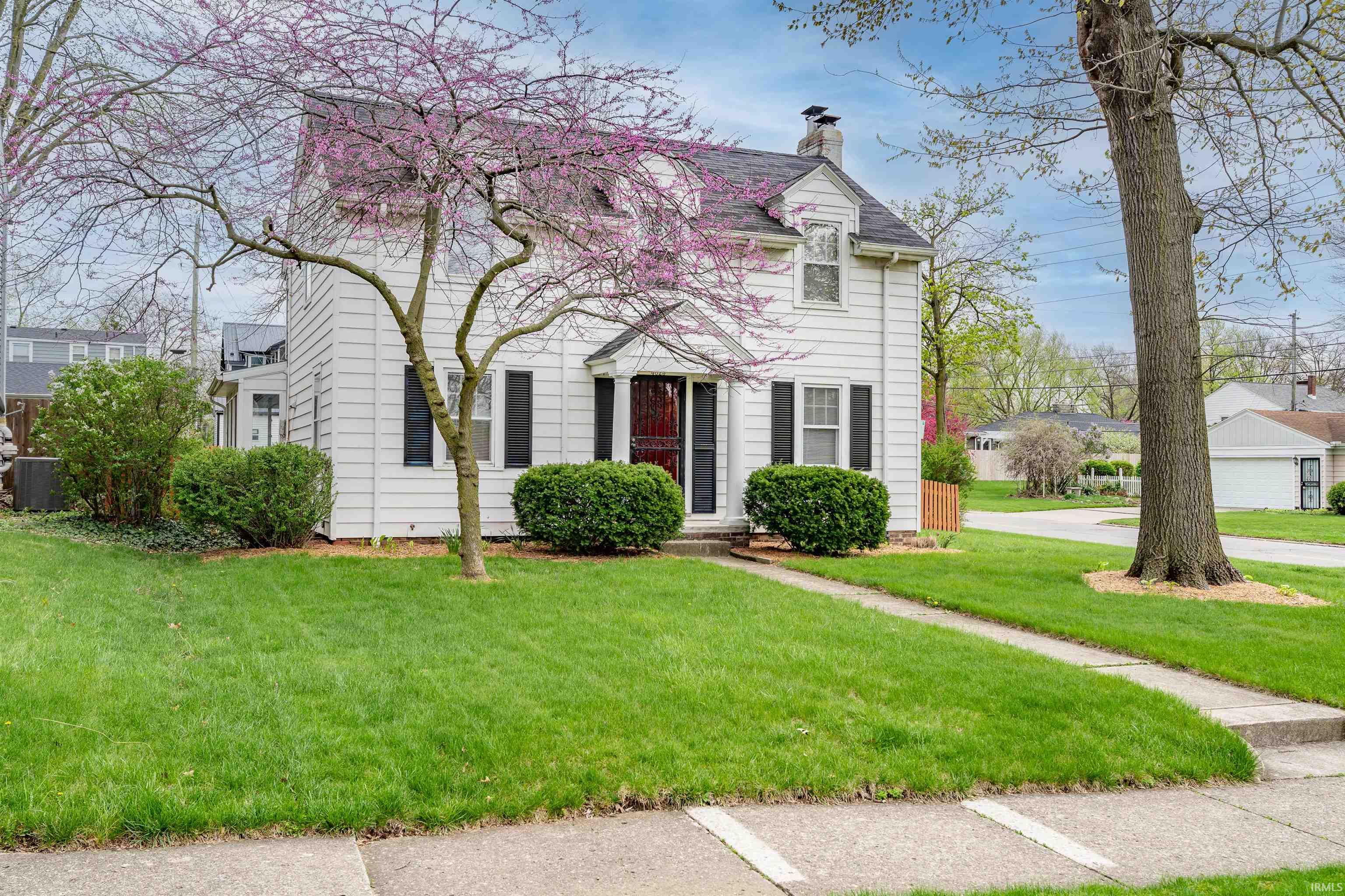 View of front of property with a front yard and a chimney