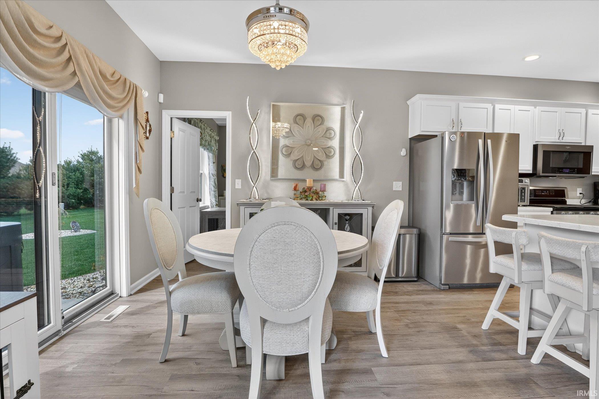 Dining area with suspended lighting and light wood-style floors