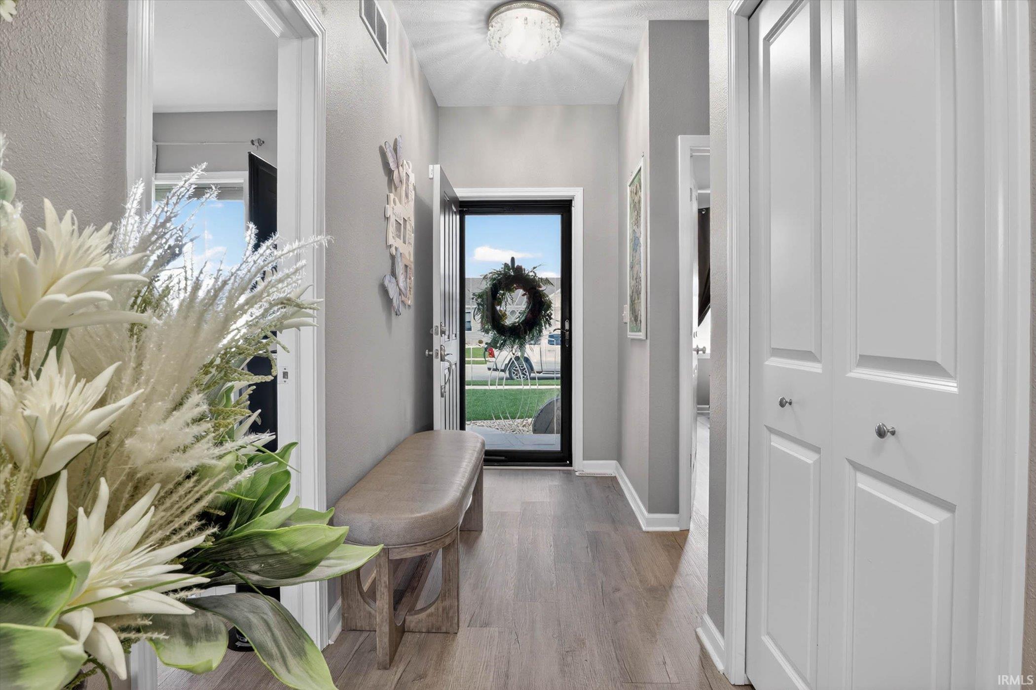 Entrance foyer featuring light wood-style floors and a textured wall