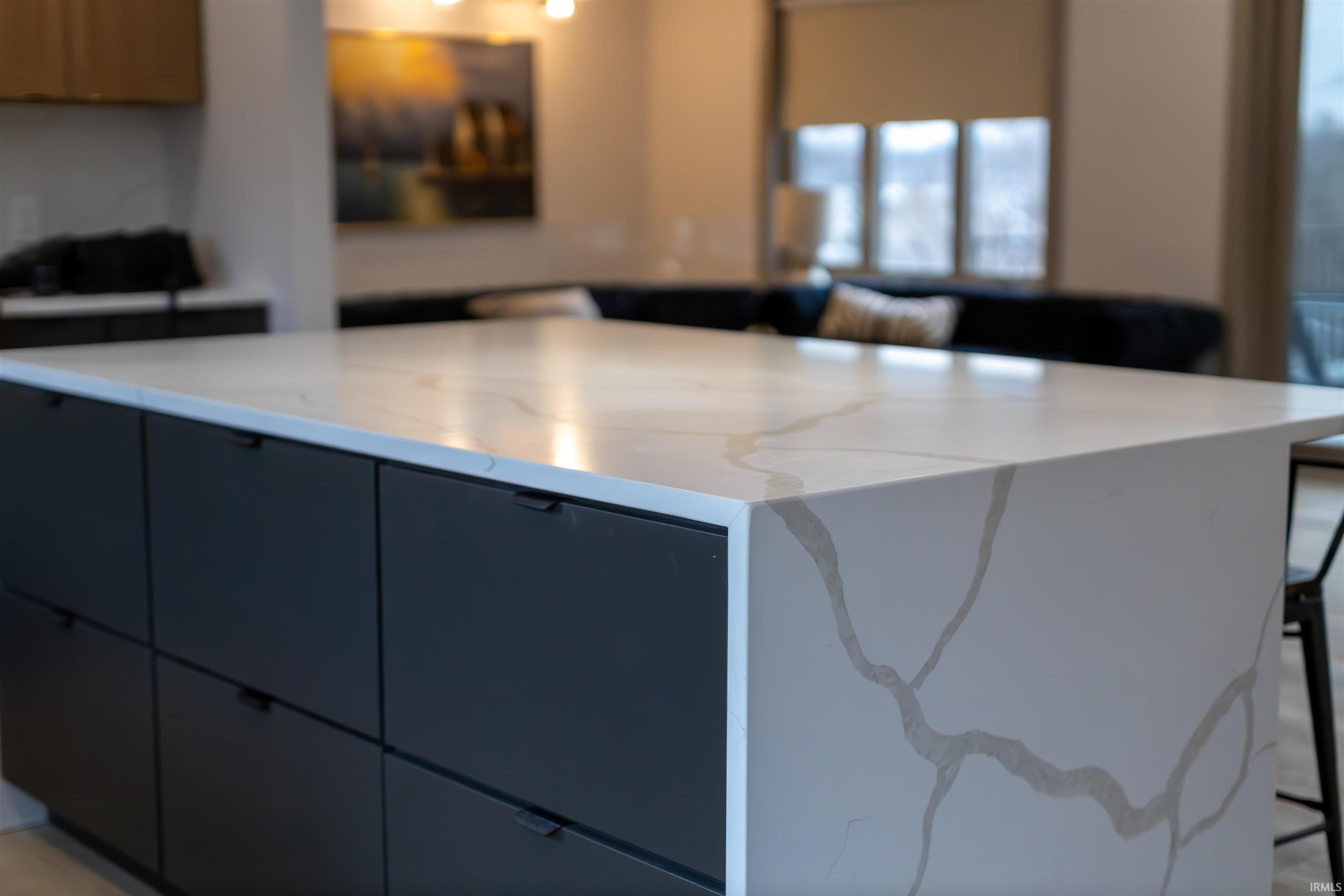Kitchen featuring a breakfast bar area, a center island, modern cabinets, and light stone countertops
