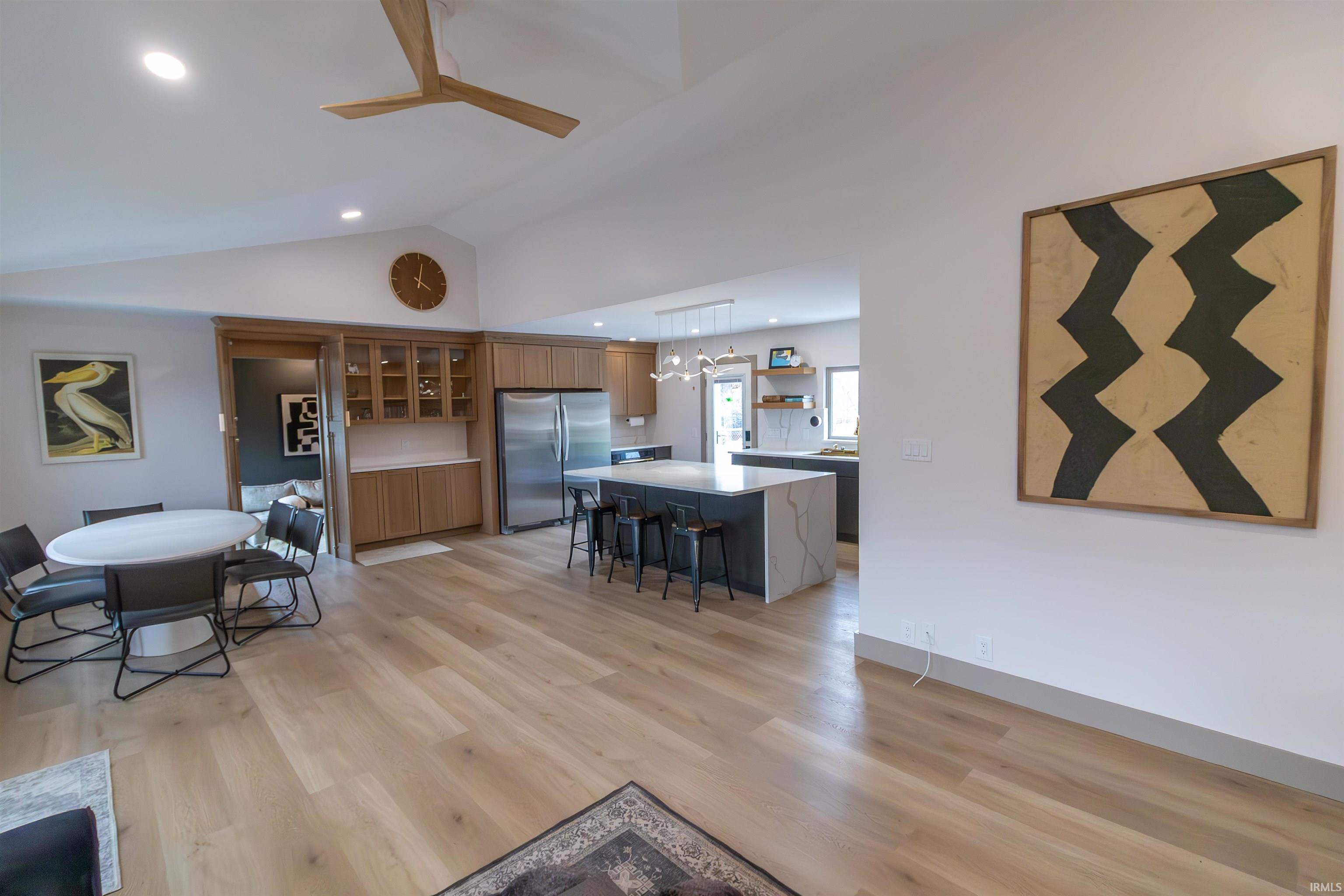 Living area featuring a ceiling fan, light wood-type flooring, lofted ceiling, and recessed lighting