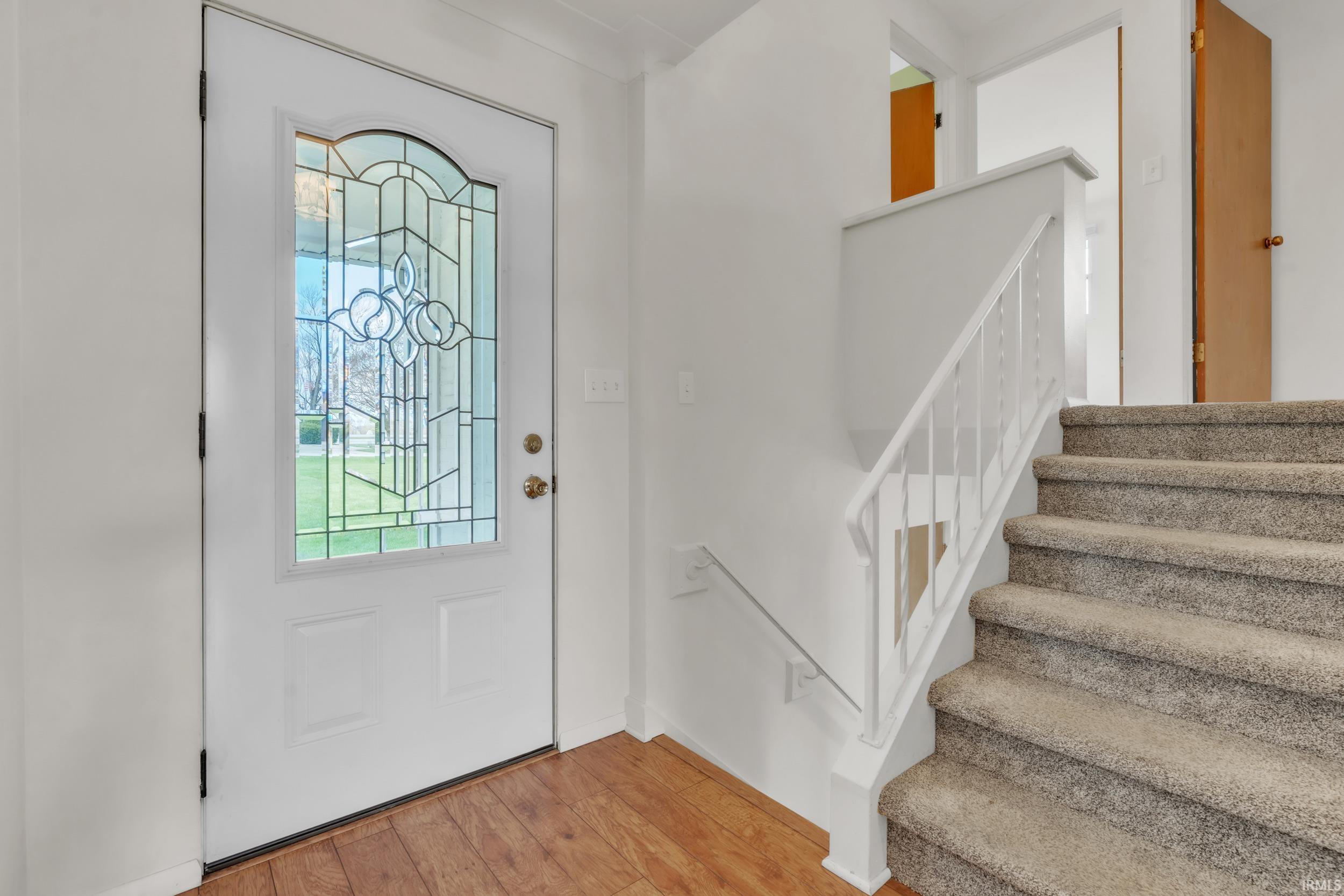 Entrance foyer featuring light wood-style flooring and stairs
