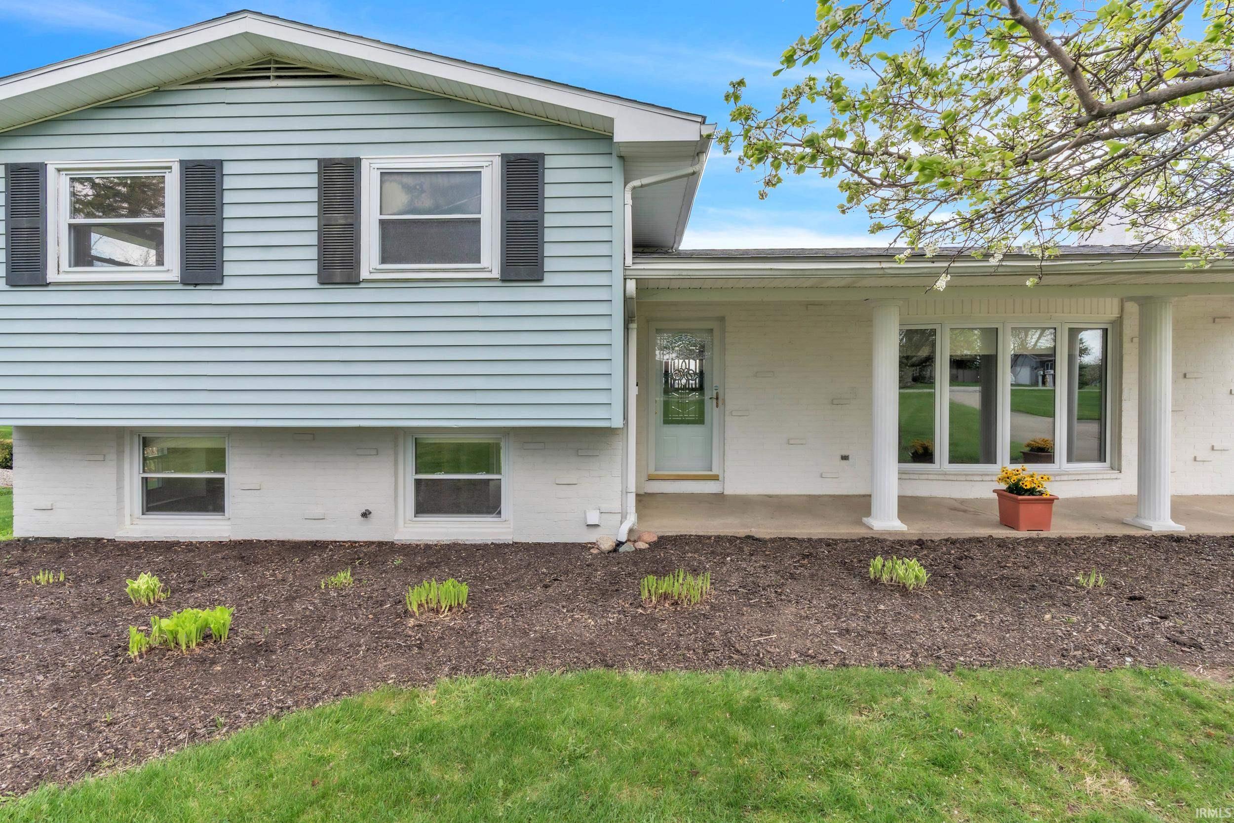 View of front of house featuring a patio and brick siding