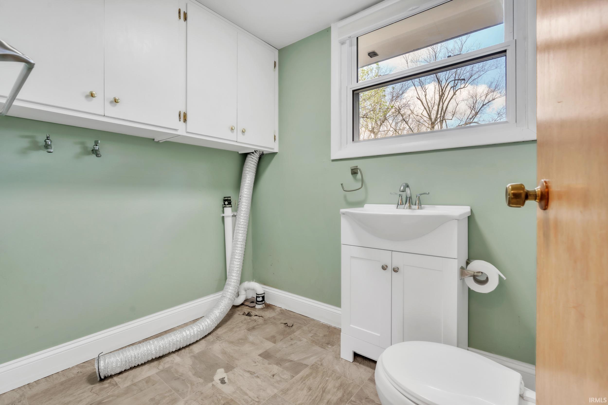 Laundry area with baseboards and a sink