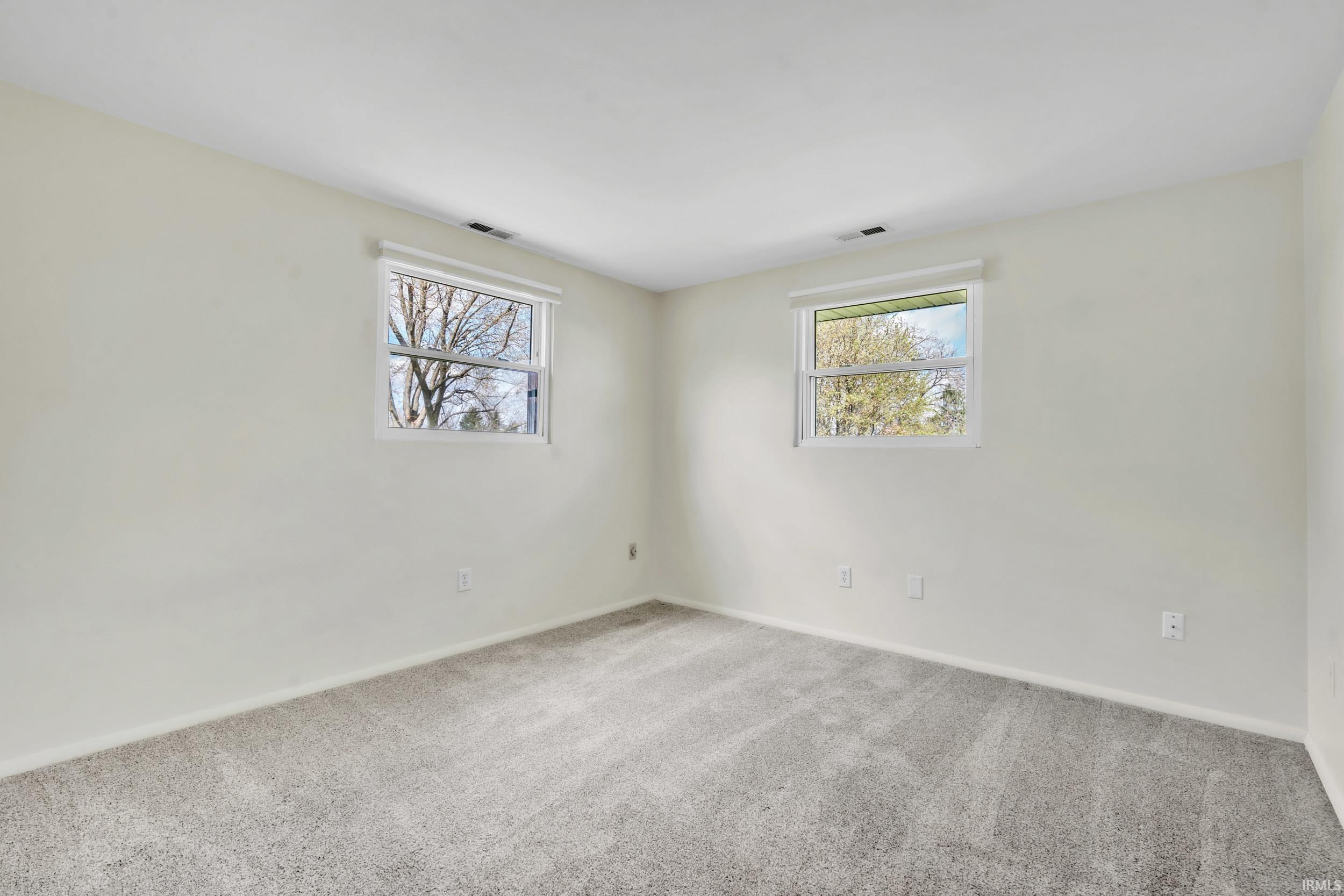 Empty room with light carpet and baseboards