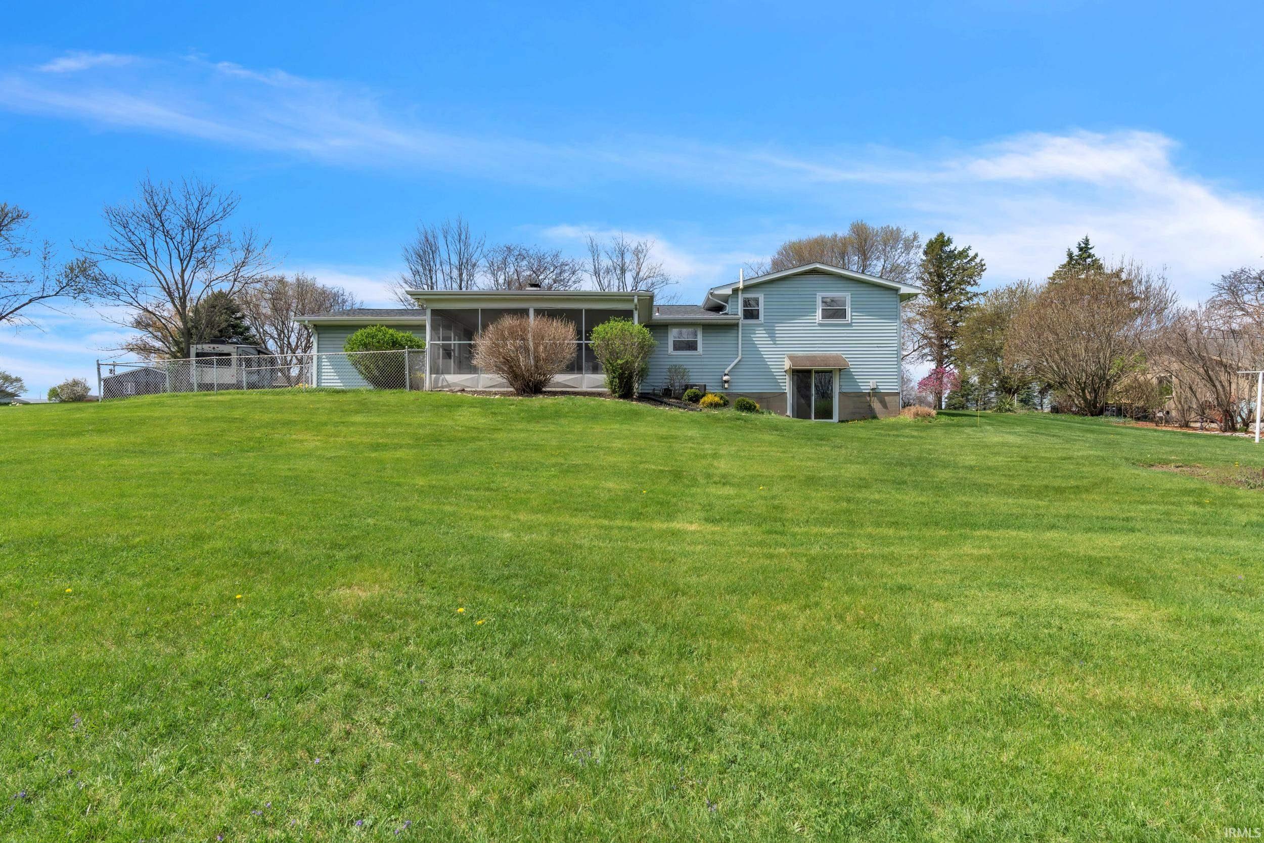 Back of property featuring a yard and a sunroom