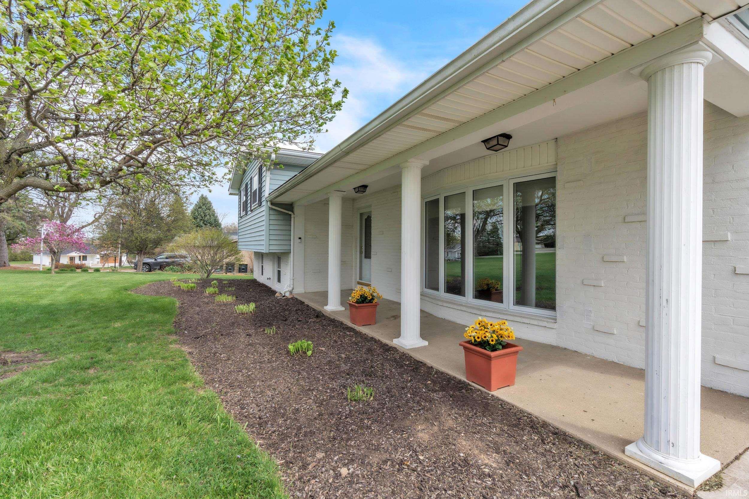Property entrance featuring a yard and brick siding
