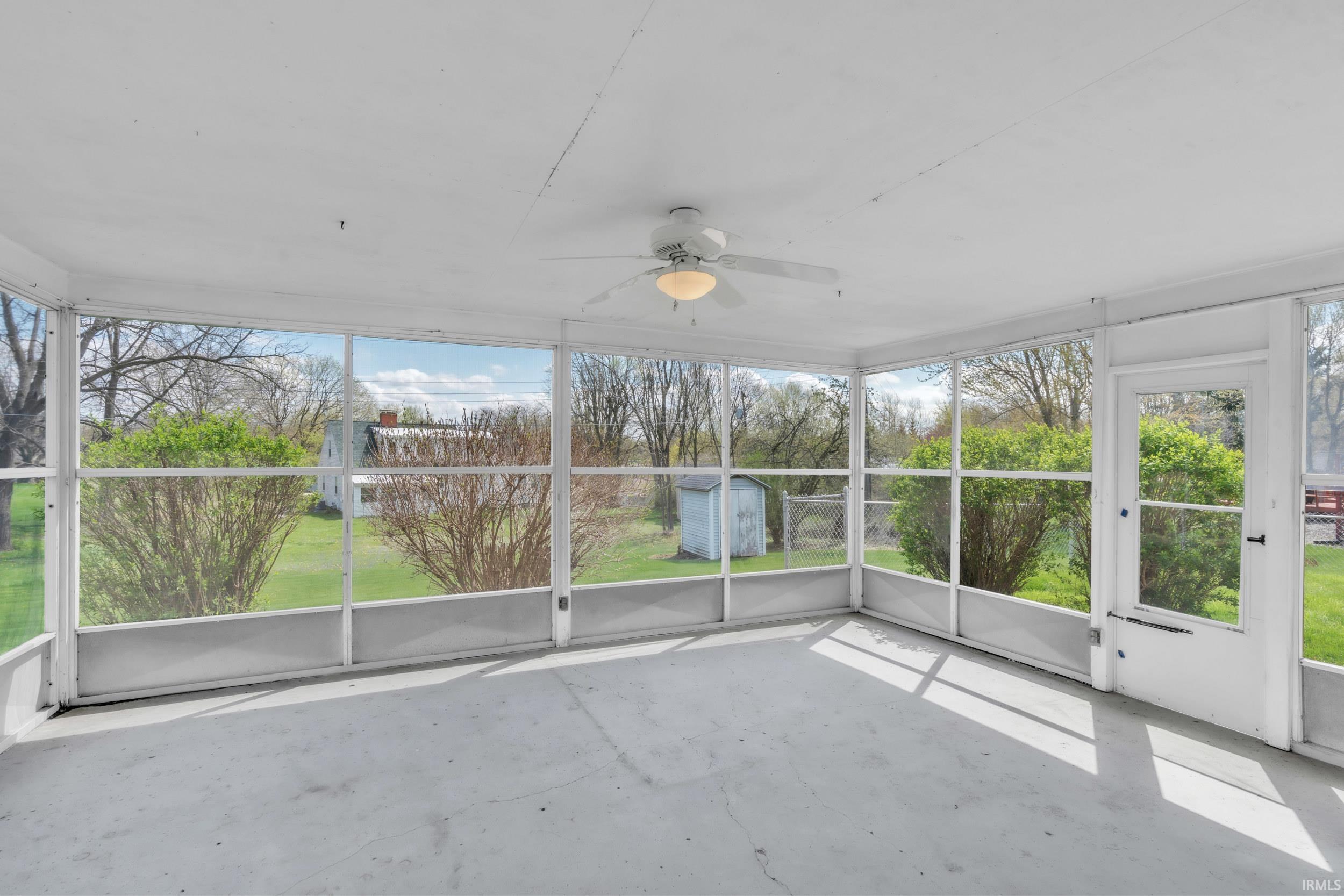 Unfurnished sunroom featuring a ceiling fan