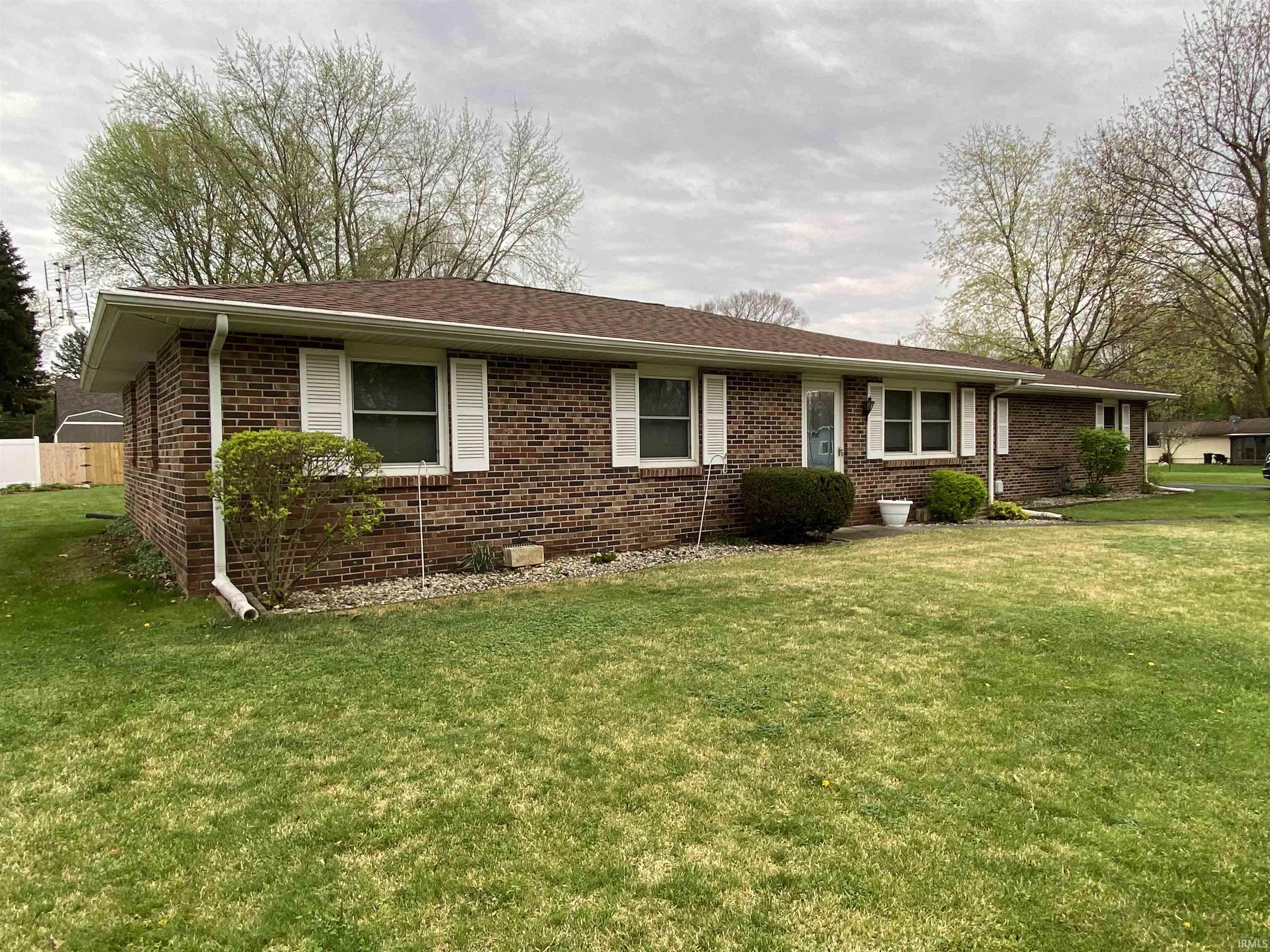 Single story home featuring a front lawn and all brick siding.